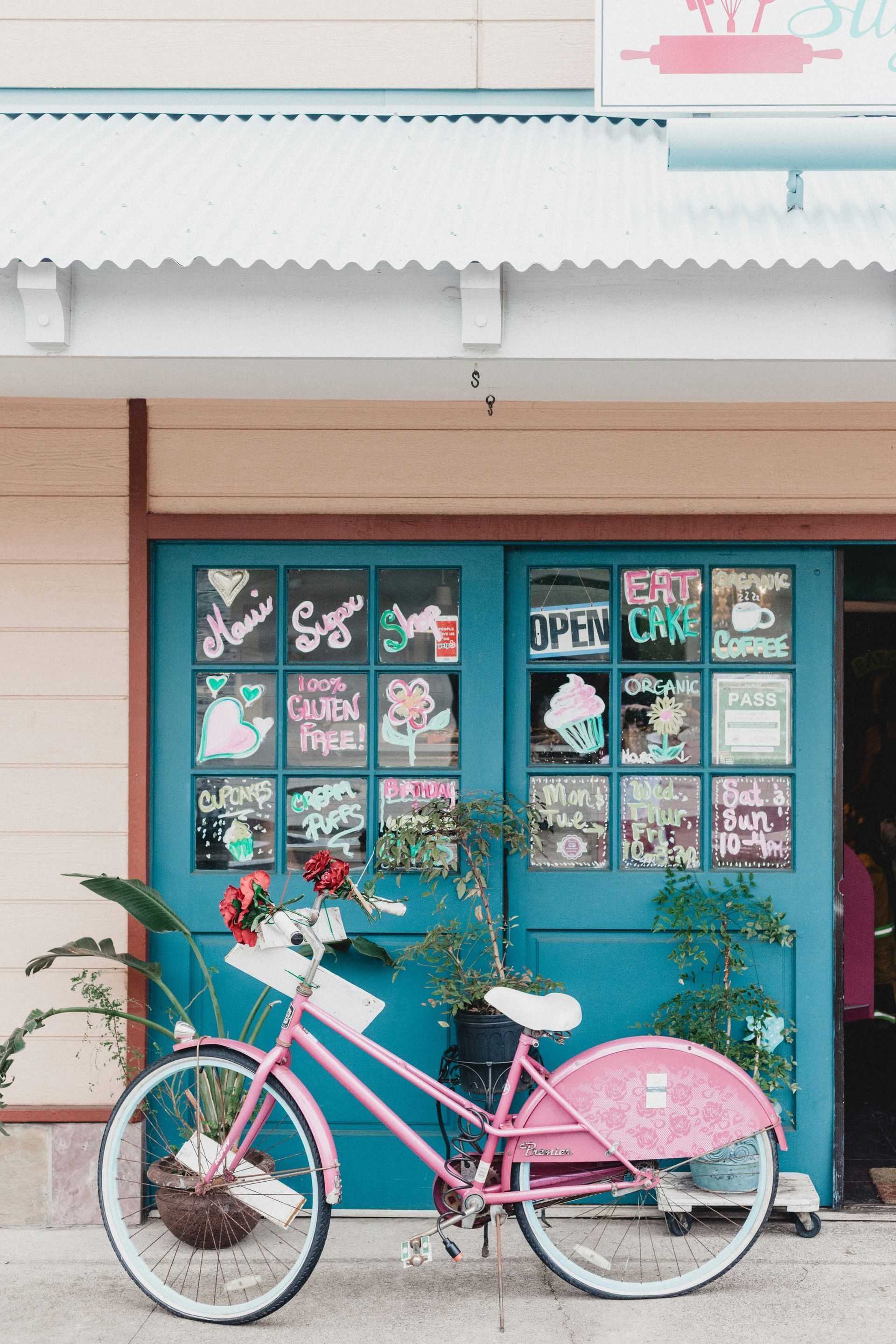 A pink bicycle is parked in front of a blue door