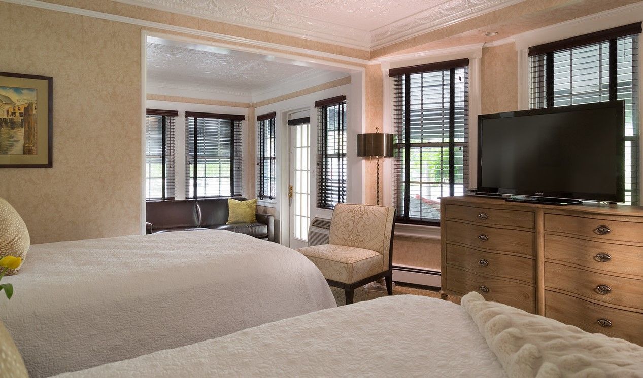 A hotel room with two beds and a flat screen tv