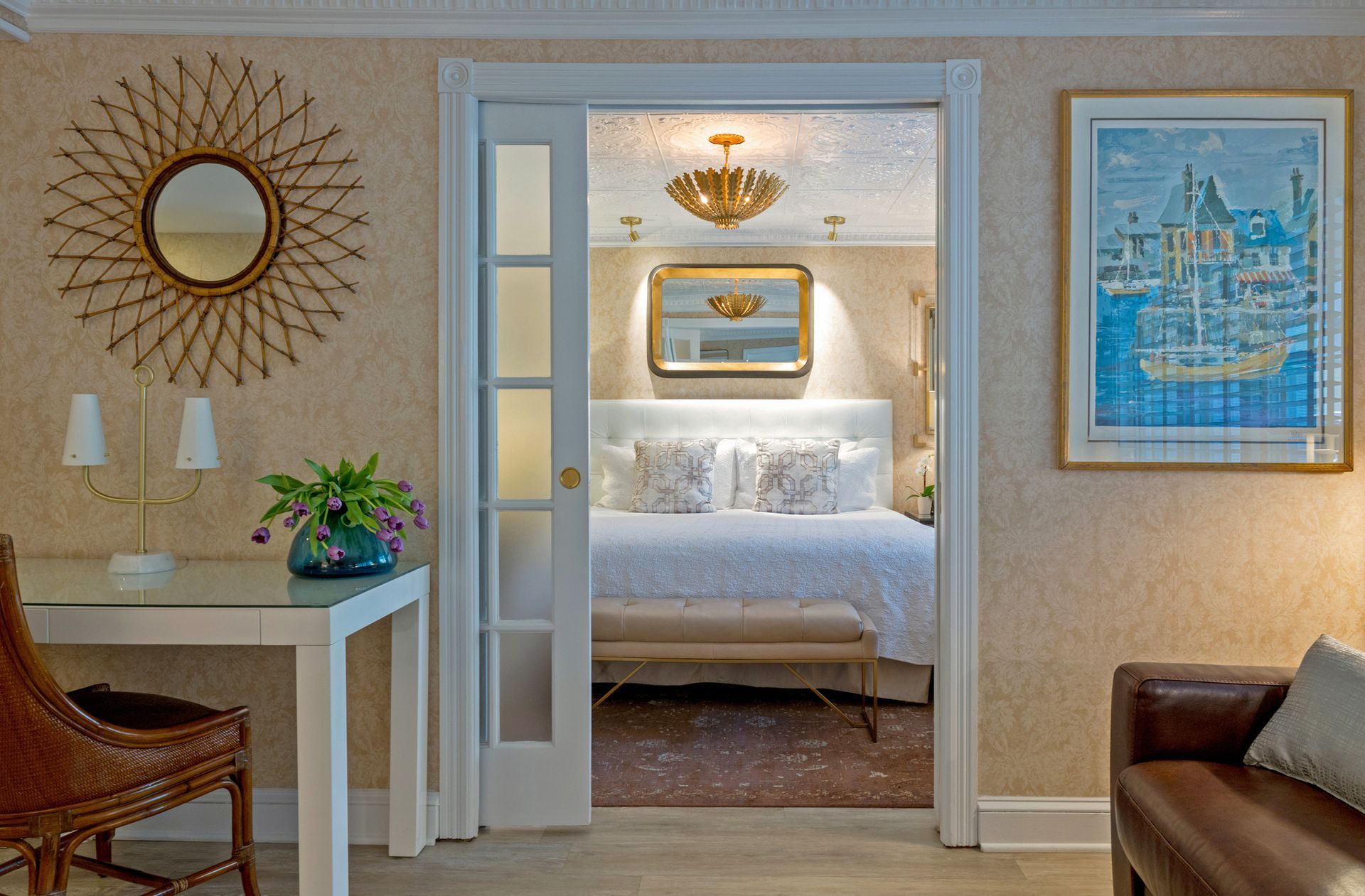 A hotel room with a sliding glass door leading to a bedroom