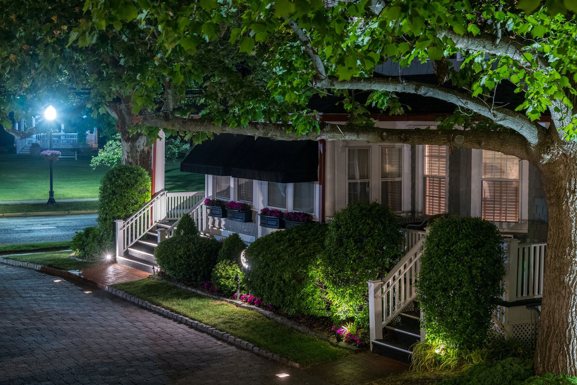 A house with a porch and stairs is lit up at night.