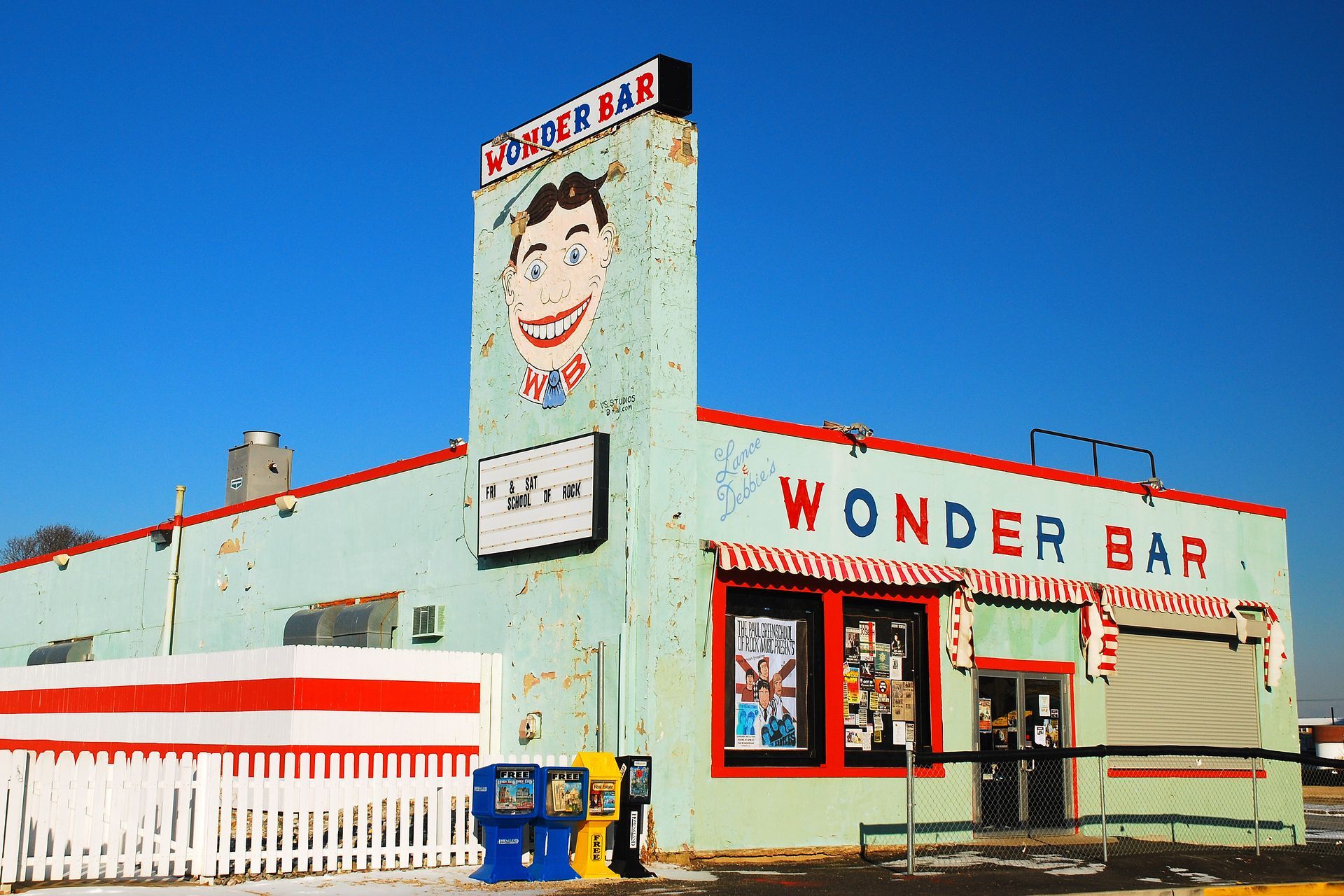 A green building with a sign that says wonder bar