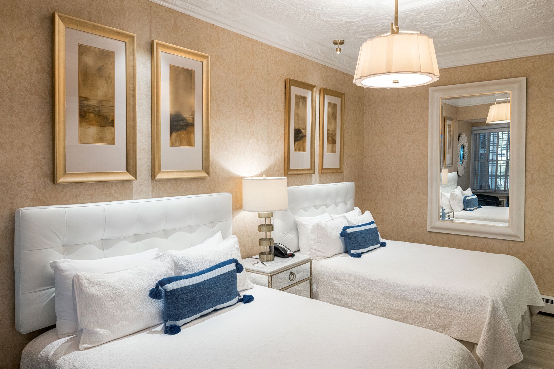 A hotel room with two beds and a large mirror.