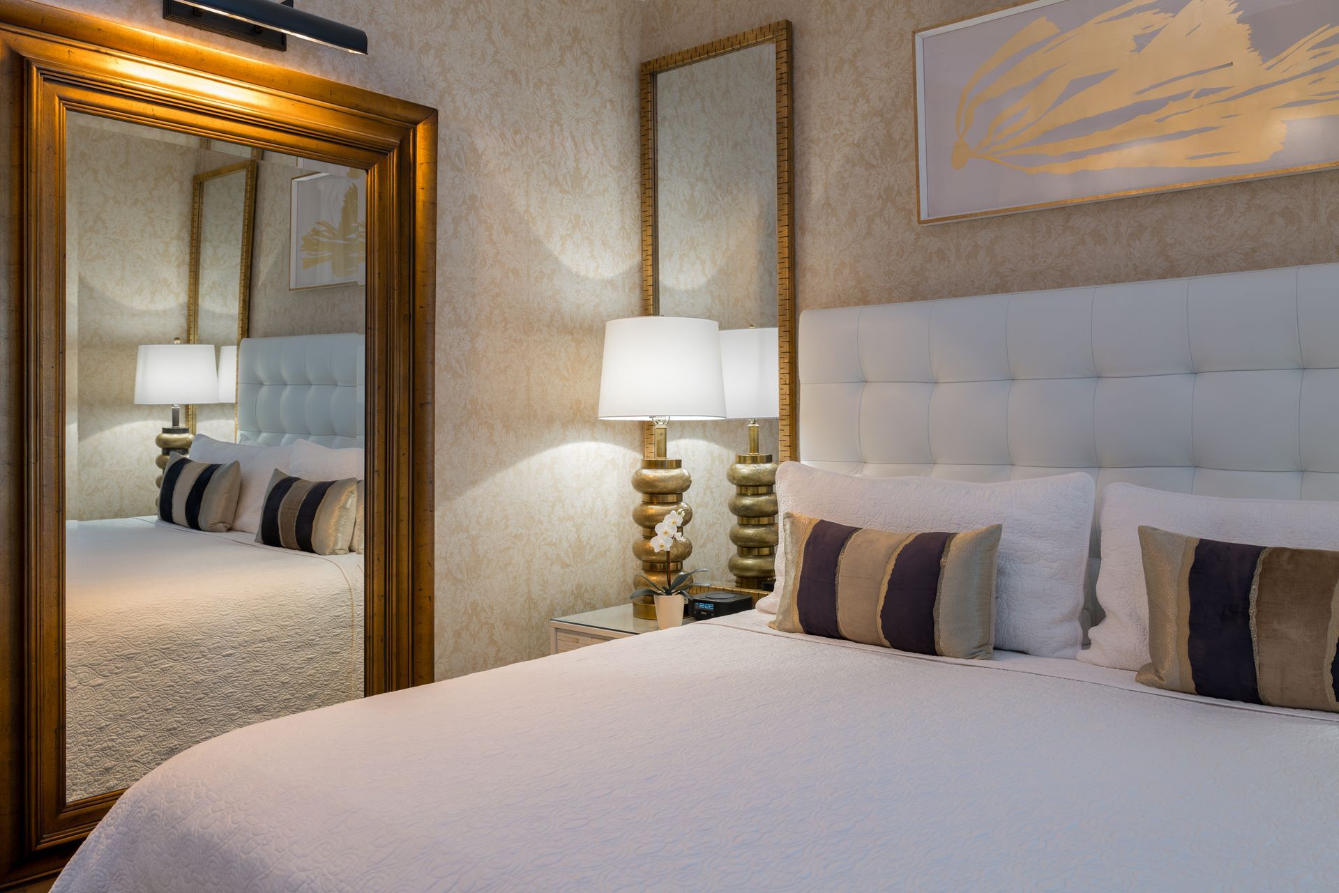 A hotel room with a large mirror and a bed.