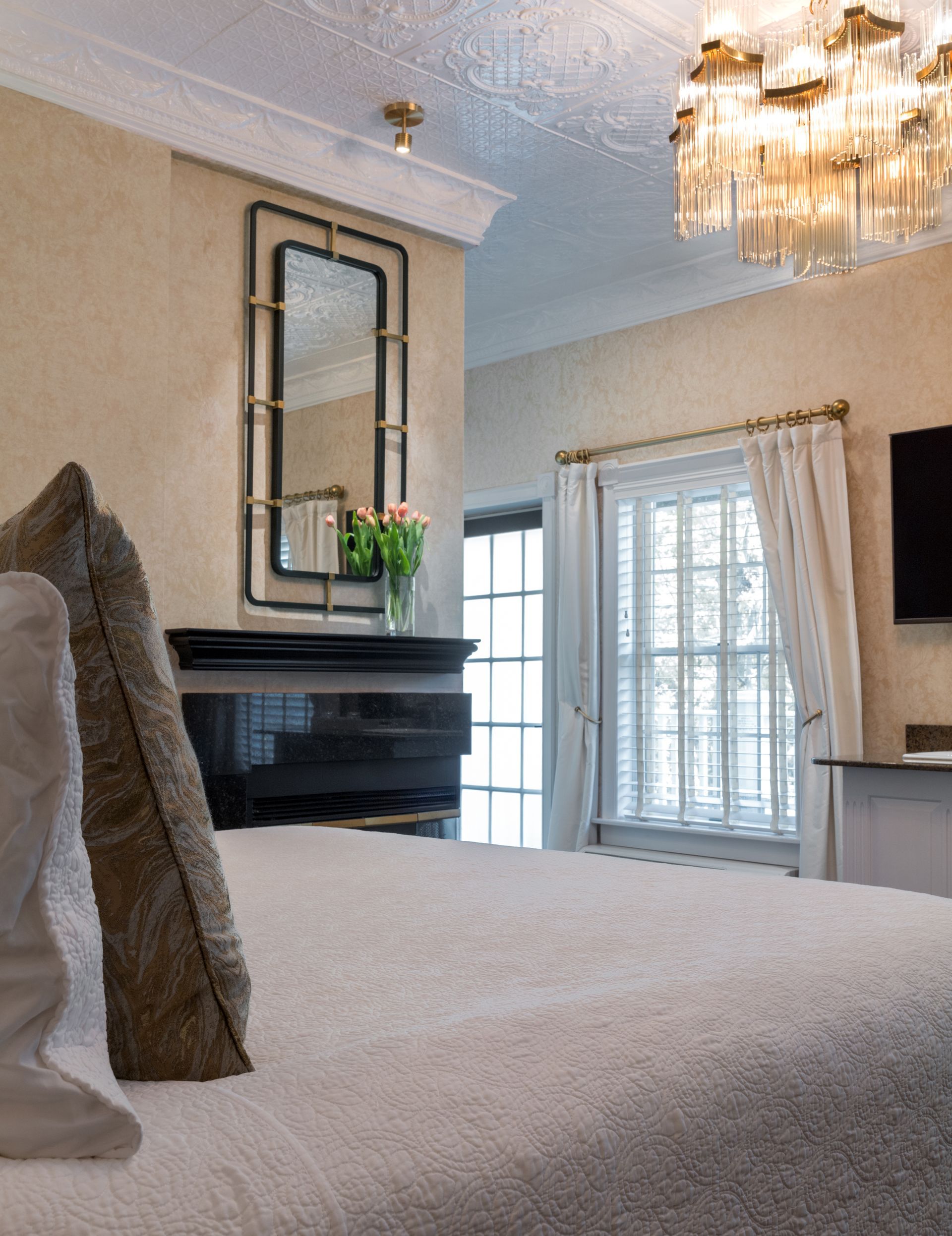 A bedroom with a large bed and a mirror on the wall