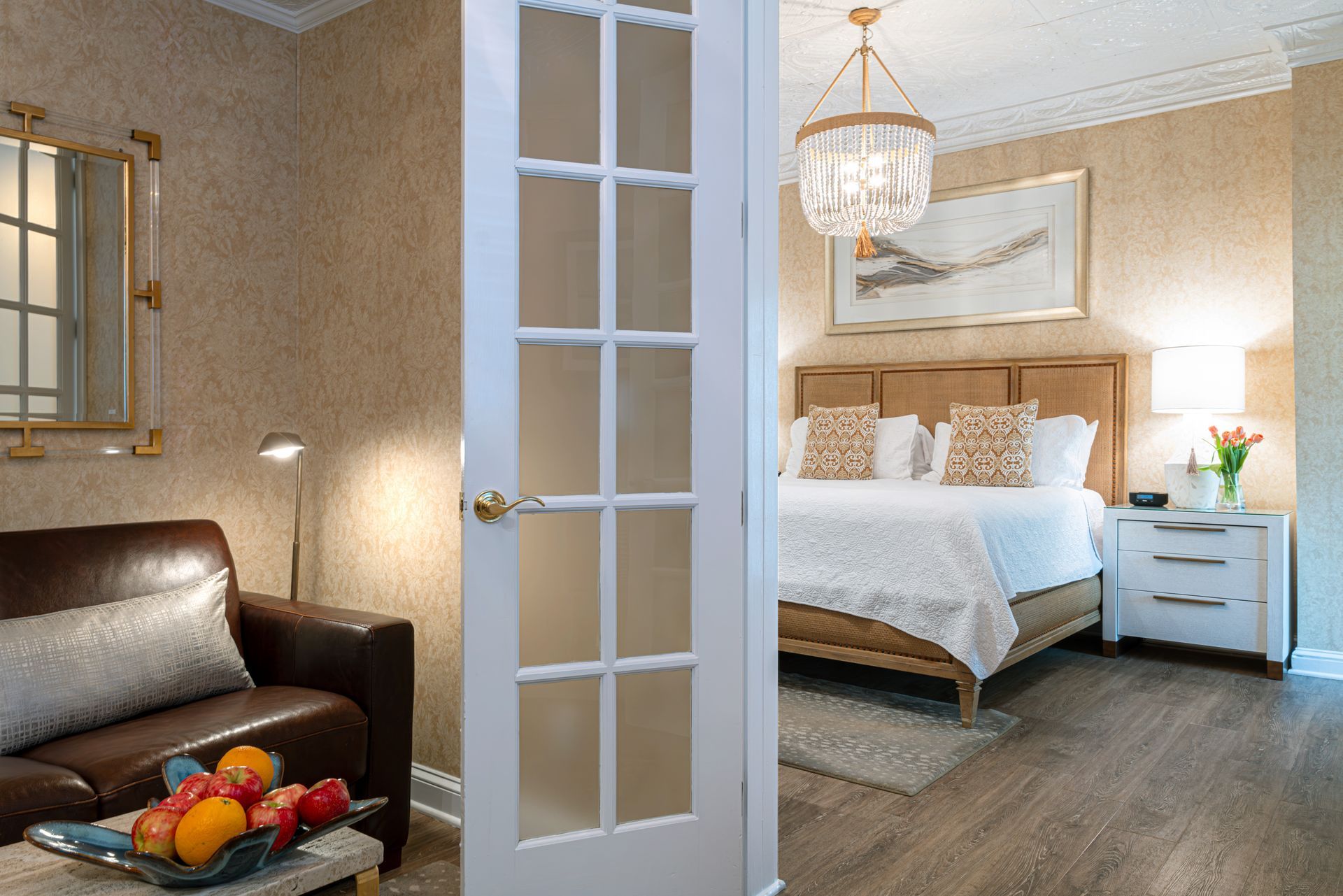 A bedroom with a king size bed and a french door leading to it.