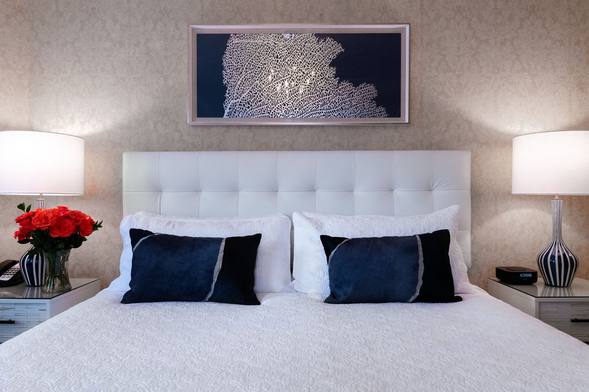 A bed with white sheets and blue pillows in a hotel room