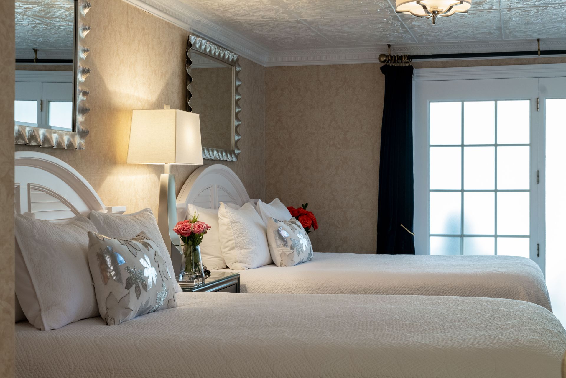 A hotel room with two beds and a mirror