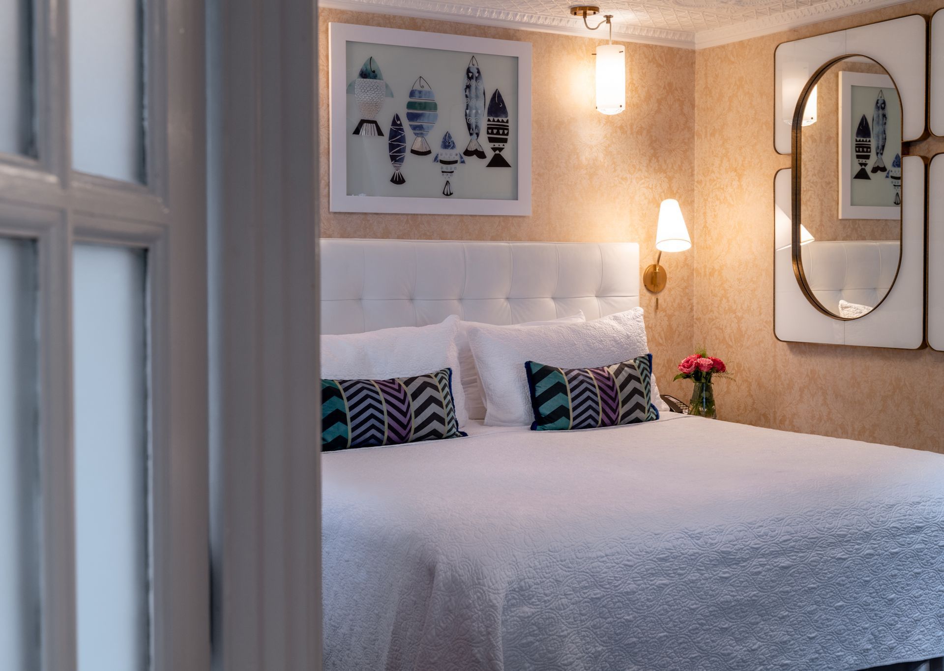 A hotel room with a king size bed and a mirror