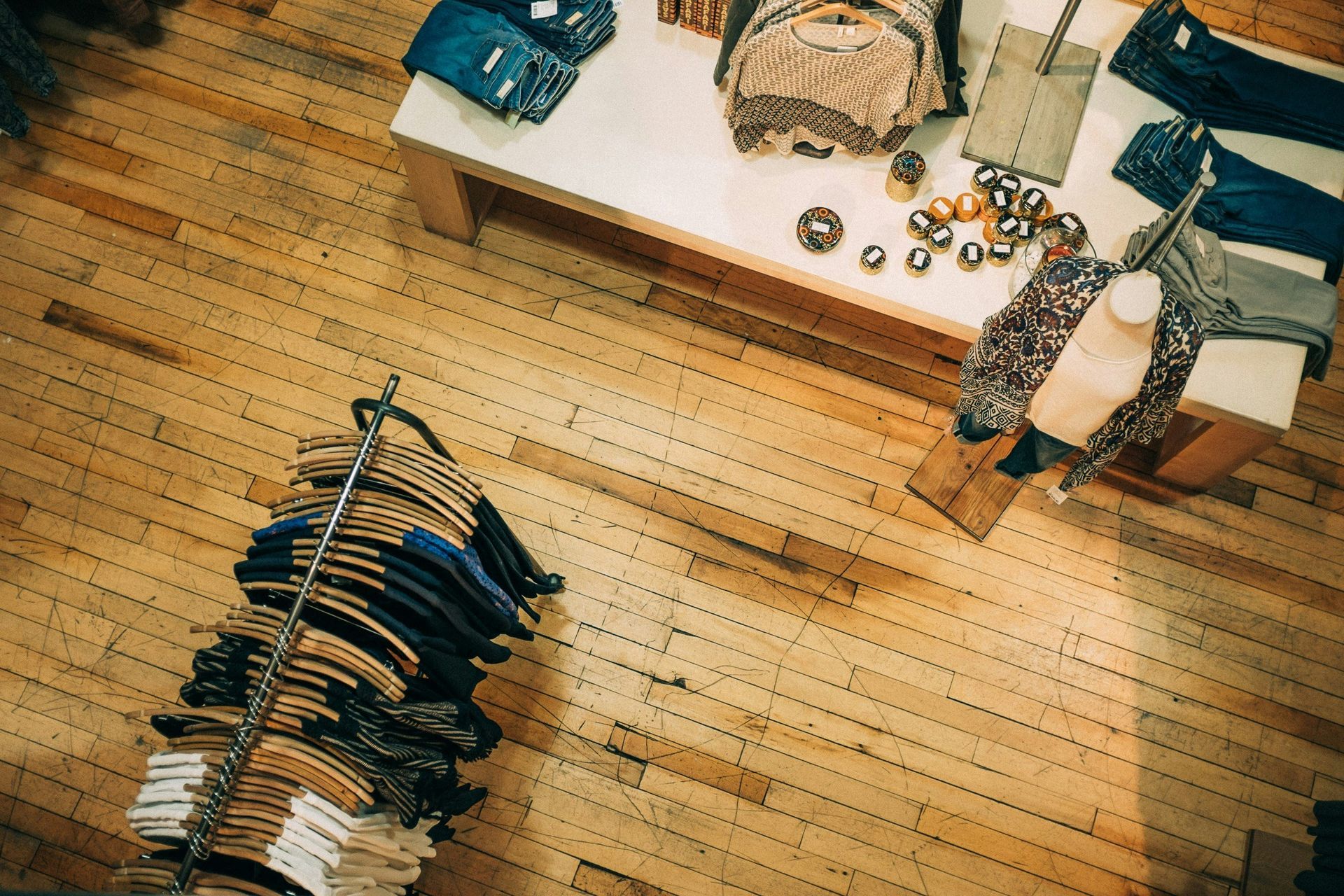 An aerial view of a clothing store with clothes hanging on racks and a table.
