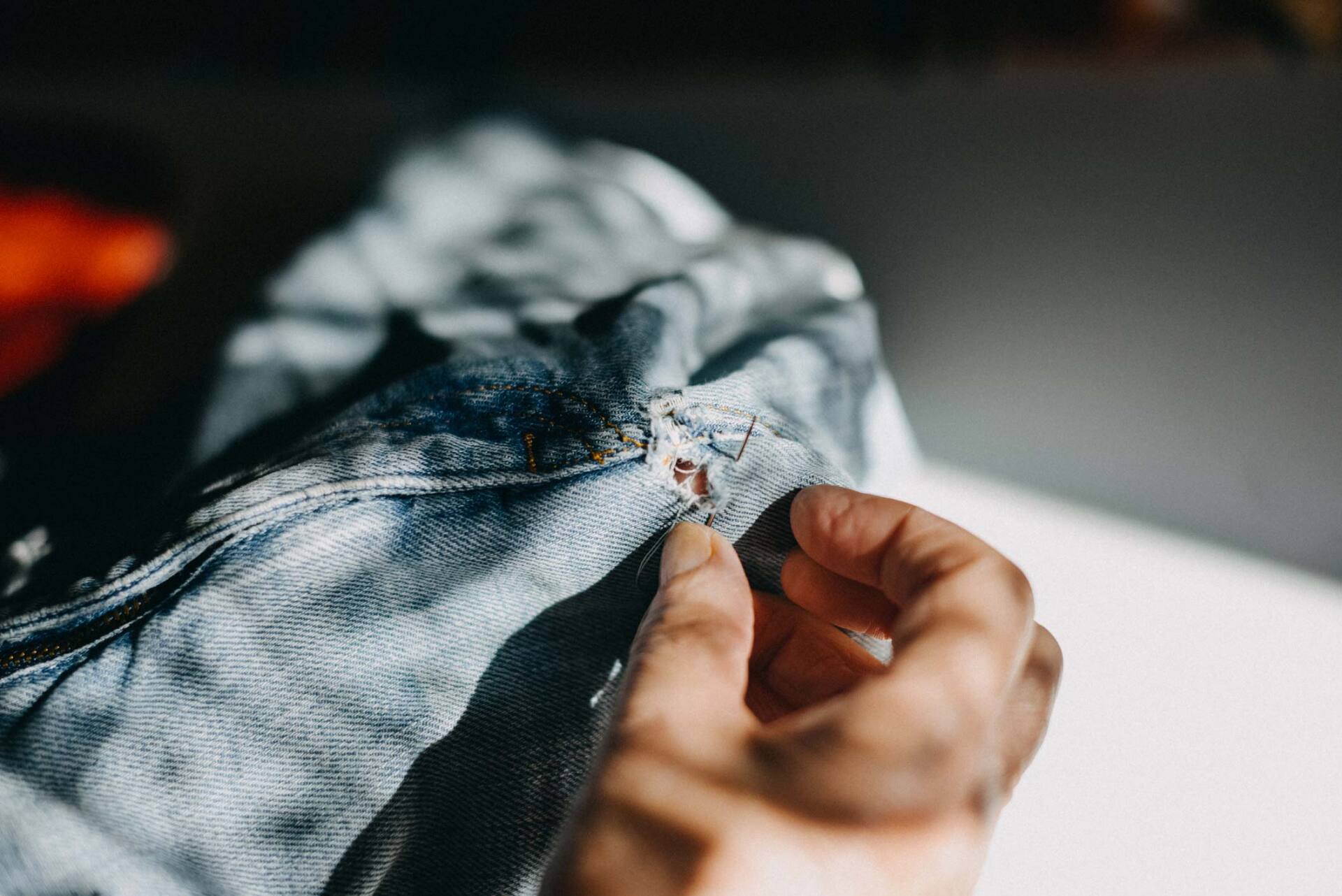 Hands sewing a pair of jeans | Wollongong, NSW | City Mode Leather