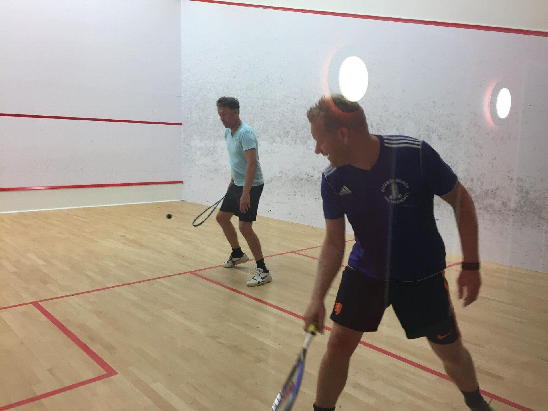 Twee mannen spelen squash op een veld