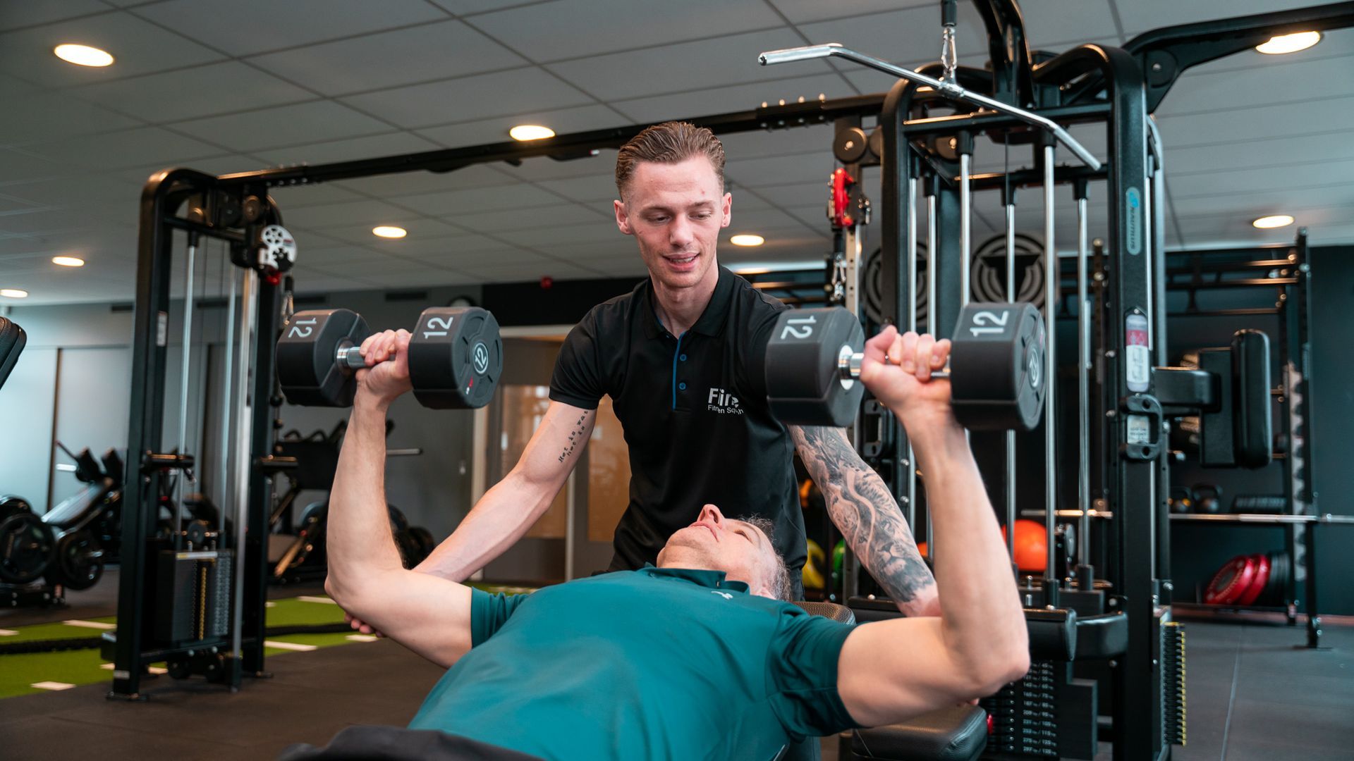 Een sportschool met veel fitnessapparatuur op de vloer