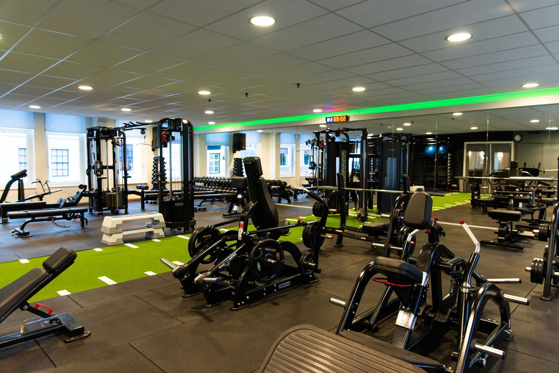 Een fitnessruimte vol met veel fitnessapparatuur en een loopband.