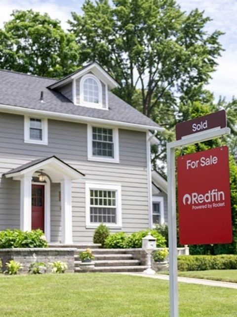 A red and white logo for rise realty