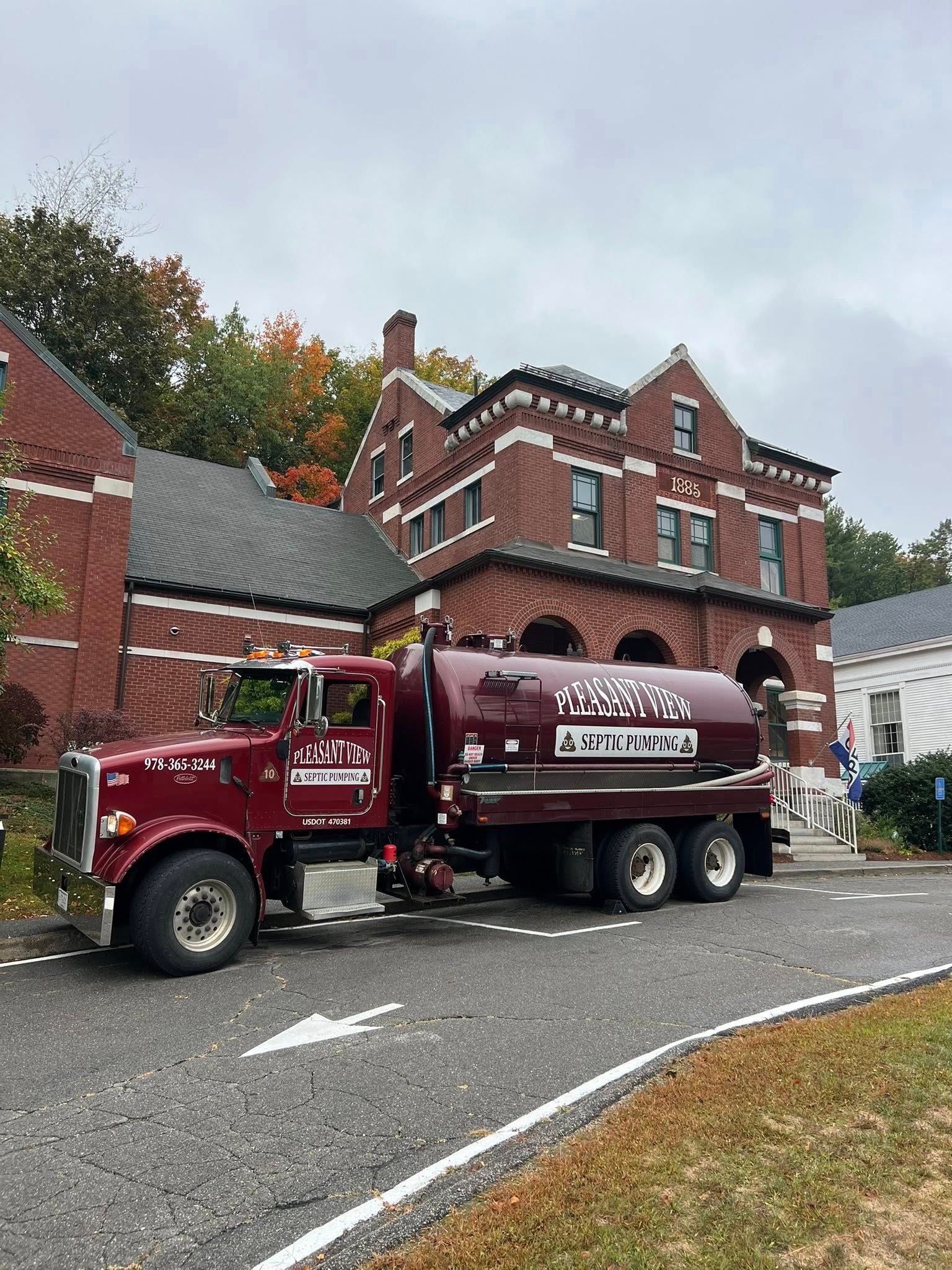 A red sewage tank trunk, pumping out sewage from a septic tank in a residential setting. A red sewage tank trunk, pumping out sewage from a septic tank in a residential setting.