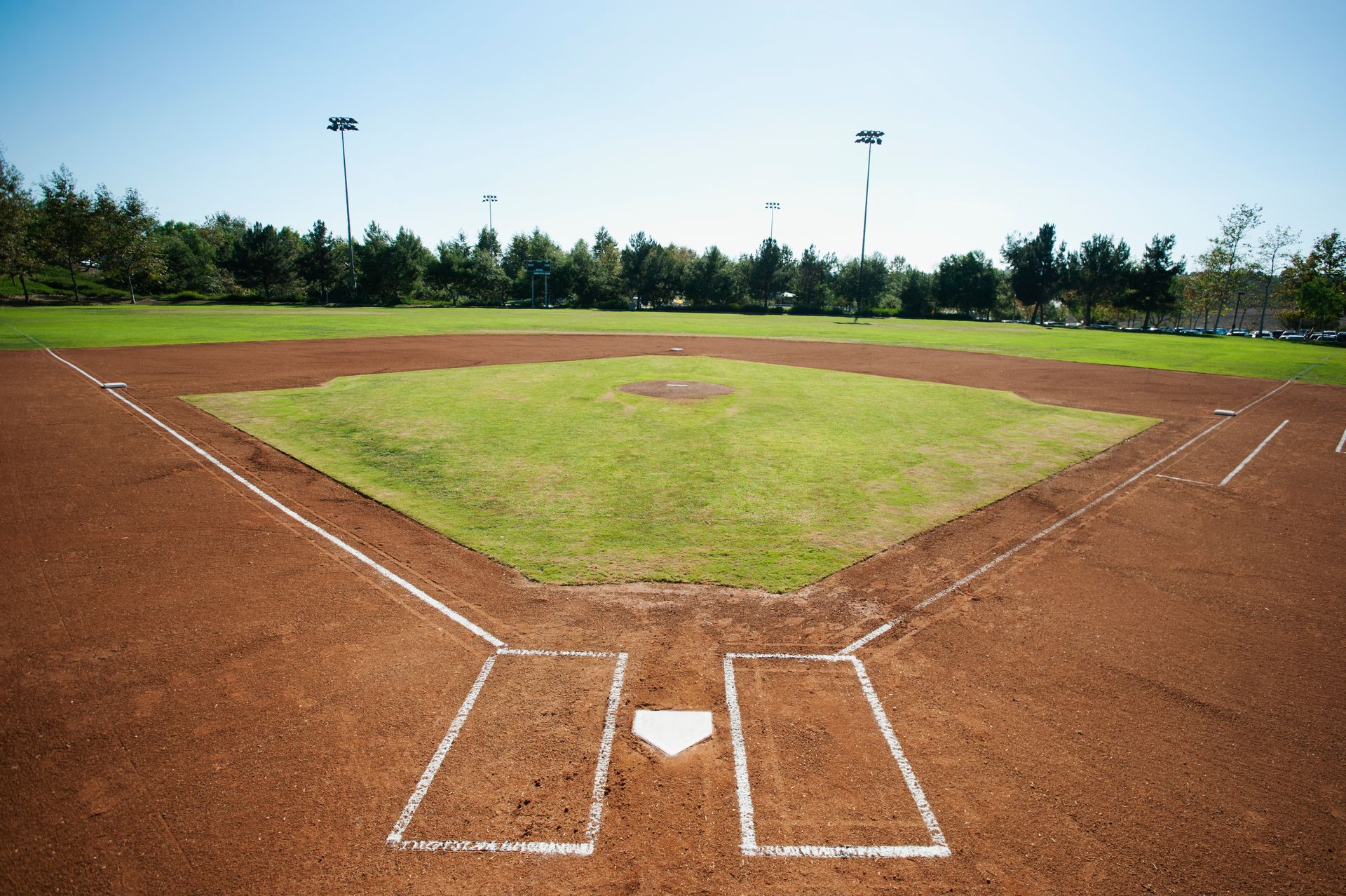 A row of orange portable toilets are lined up in front of a building.