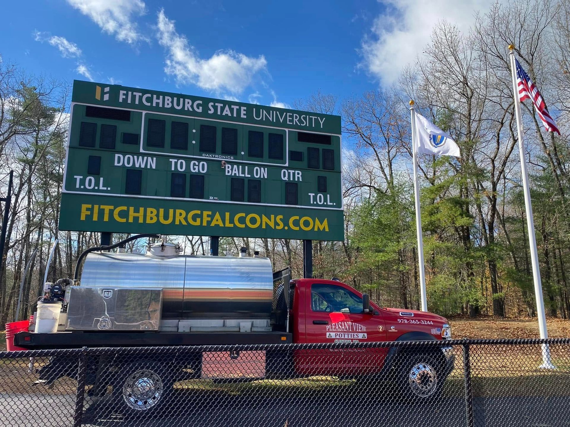 A row of blue portable toilets with yellow tops