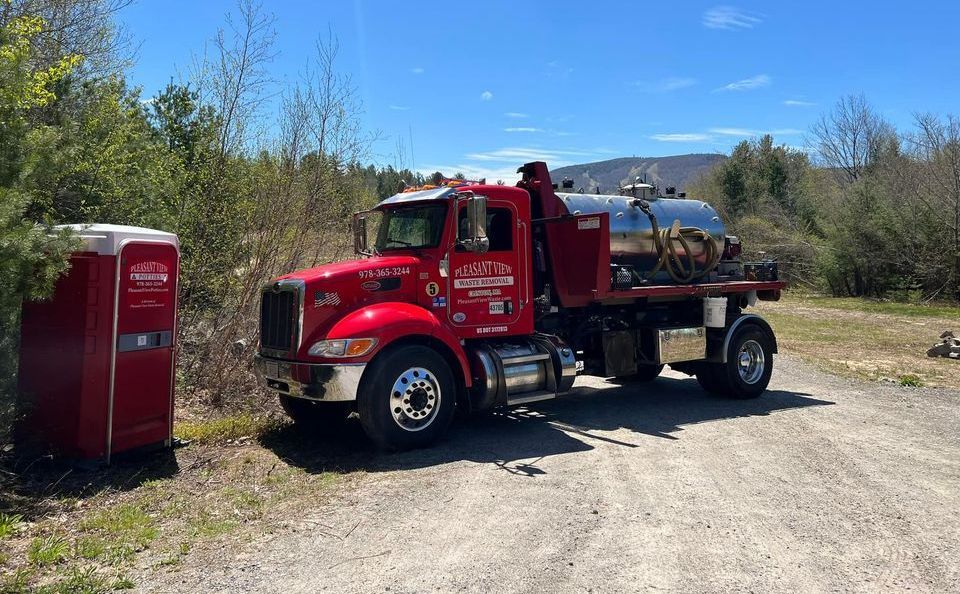 A person wearing orange gloves is connecting a hose to a pipe.