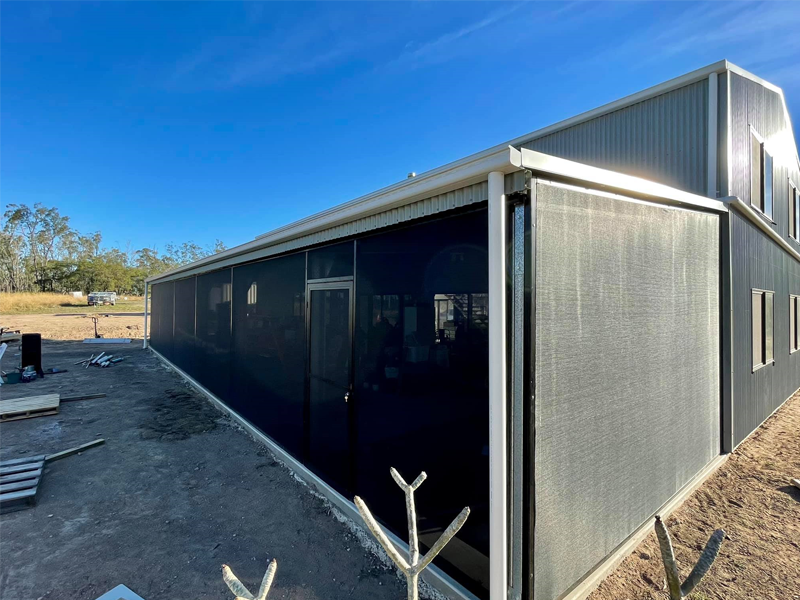 A Large Building With A Screen On The Side Of It — Affordable Screens & Blinds in Thabeban, QLD