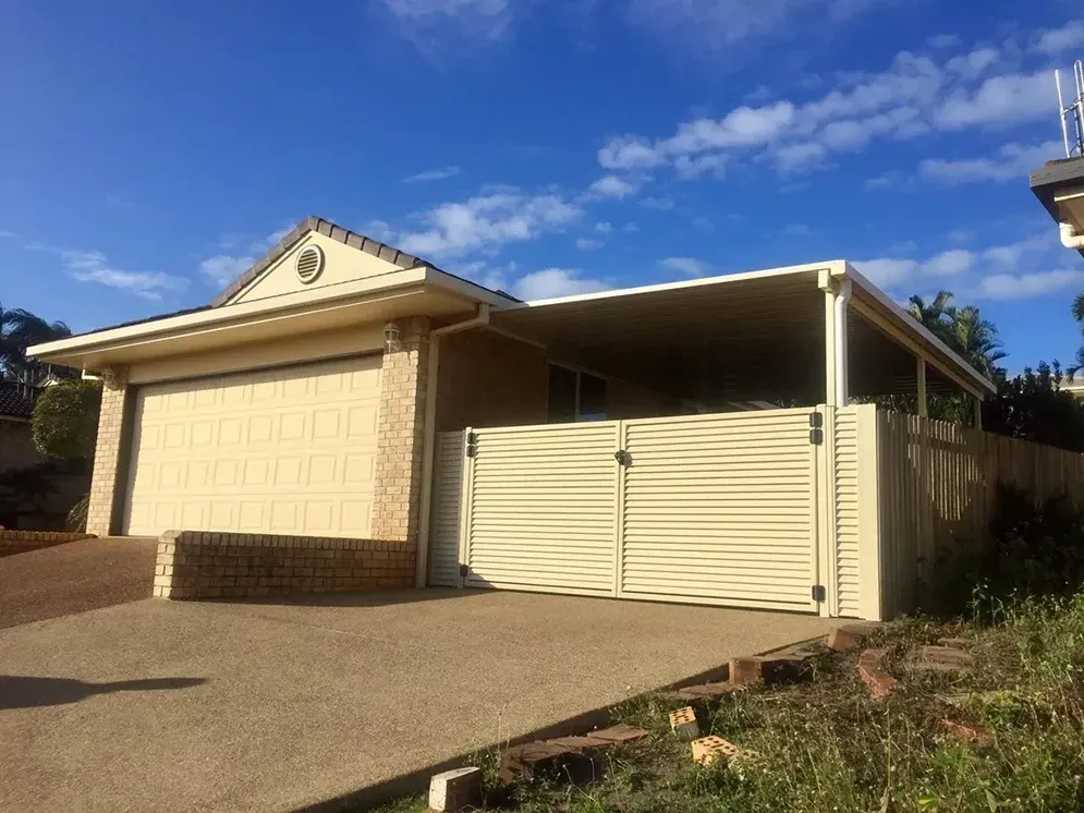 A House With A Garage And A Fence In Front Of It — Affordable Screens & Blinds in Thabeban, QLD