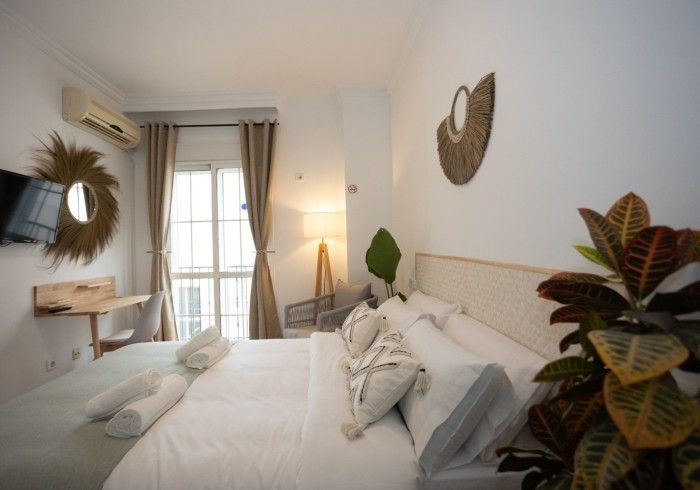 Un dormitorio con una cama grande, un escritorio, una silla y una ventana.