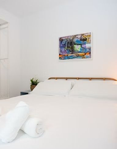Un dormitorio con una cama y un cuadro en la pared encima.