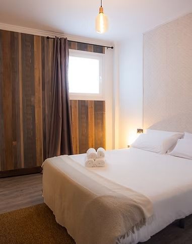 Un dormitorio con una cama grande y una ventana.
