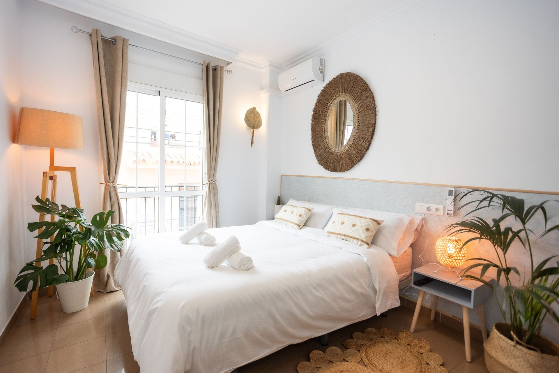 Un dormitorio con una cama, un escritorio, una silla y un espejo.