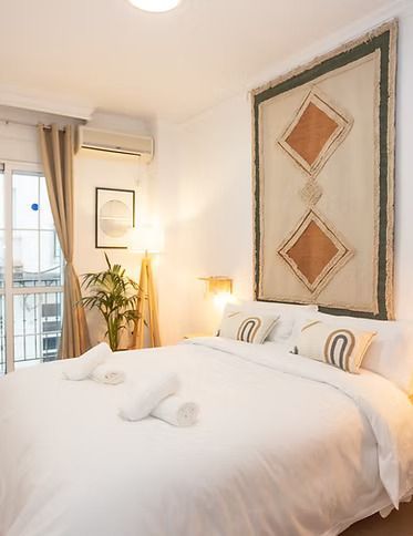 Un dormitorio con una cama grande y un cuadro en la pared.