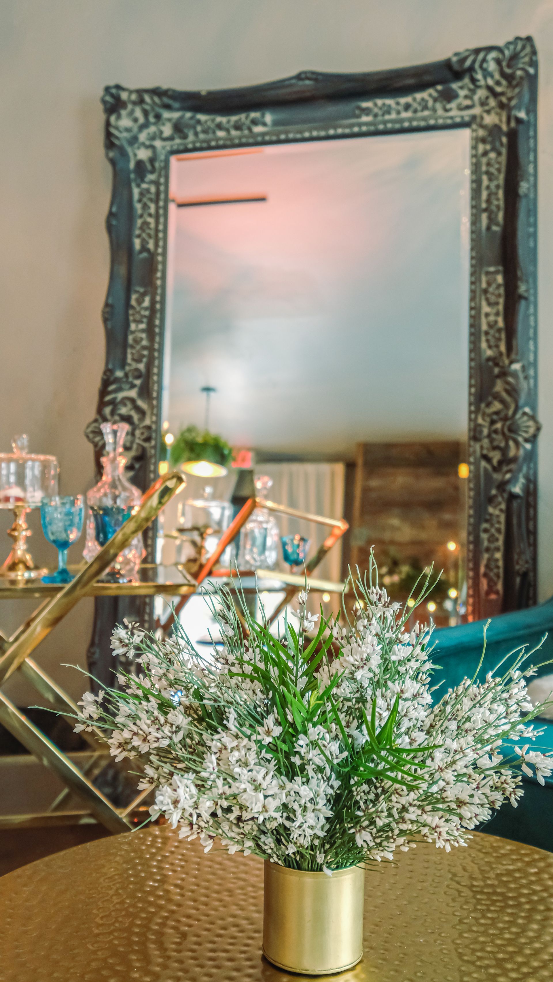 A vase of flowers is sitting on a table in front of a mirror.