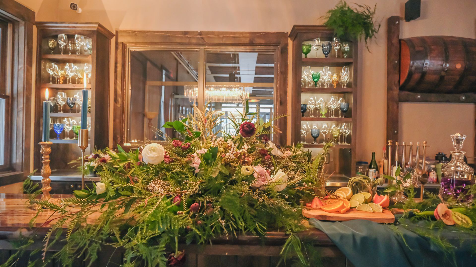 A long table with flowers and candles on it in a room.