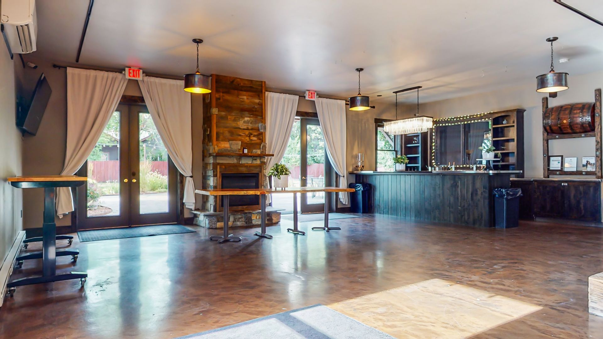 A large empty room with tables and a fireplace.
