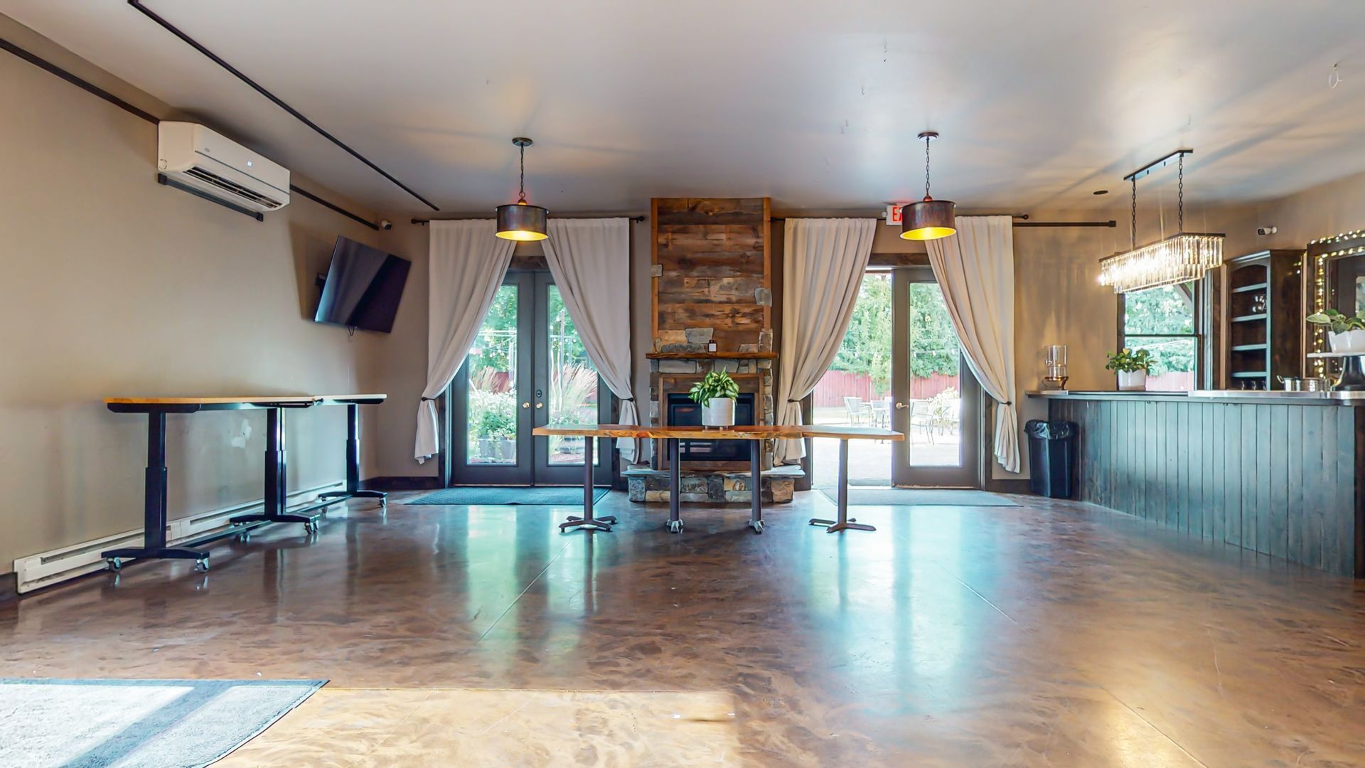 A large room with tables and a bar in it.