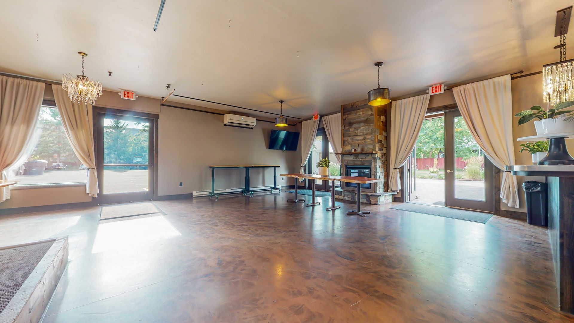 A large empty room with hardwood floors and a fireplace.