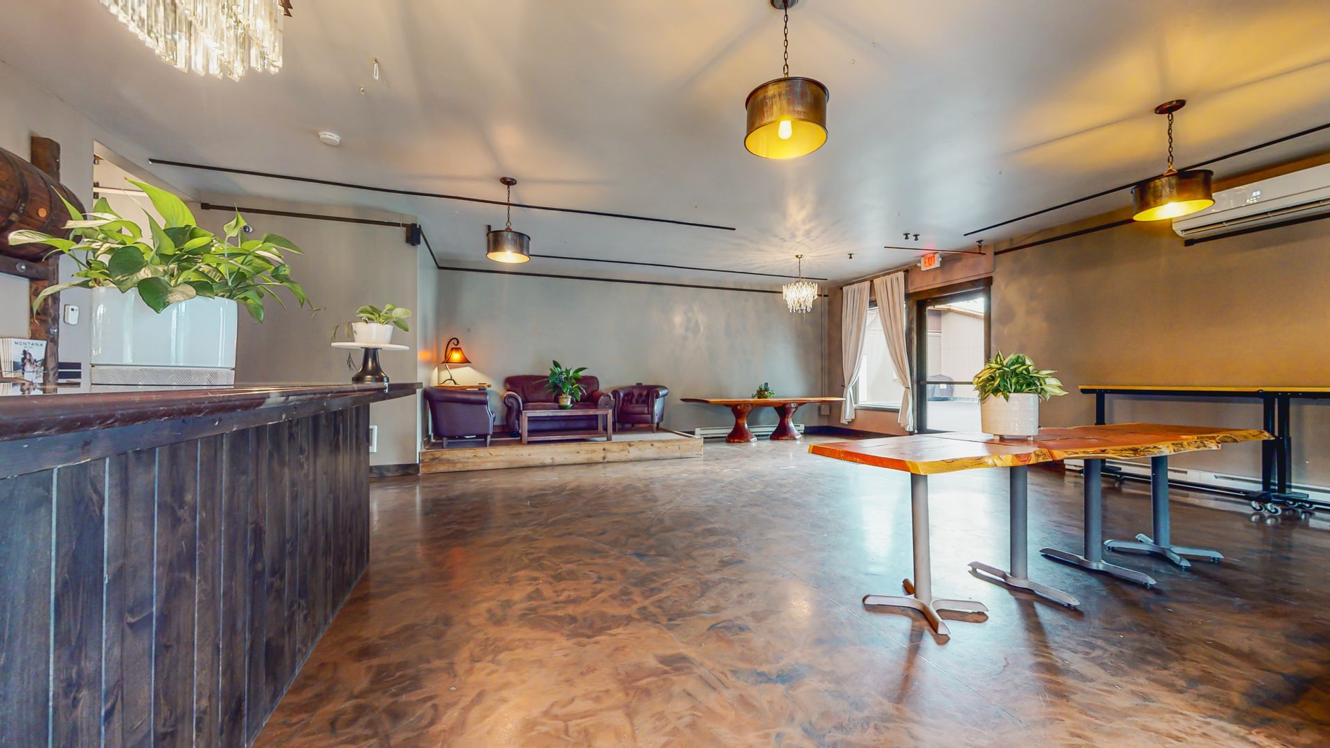 A large room with tables and chairs and a counter.