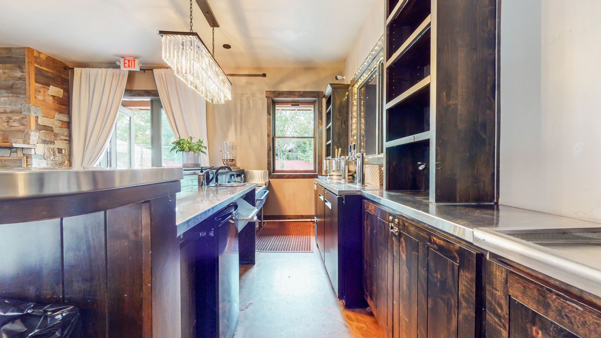 A long kitchen with wooden cabinets and stainless steel counter tops.