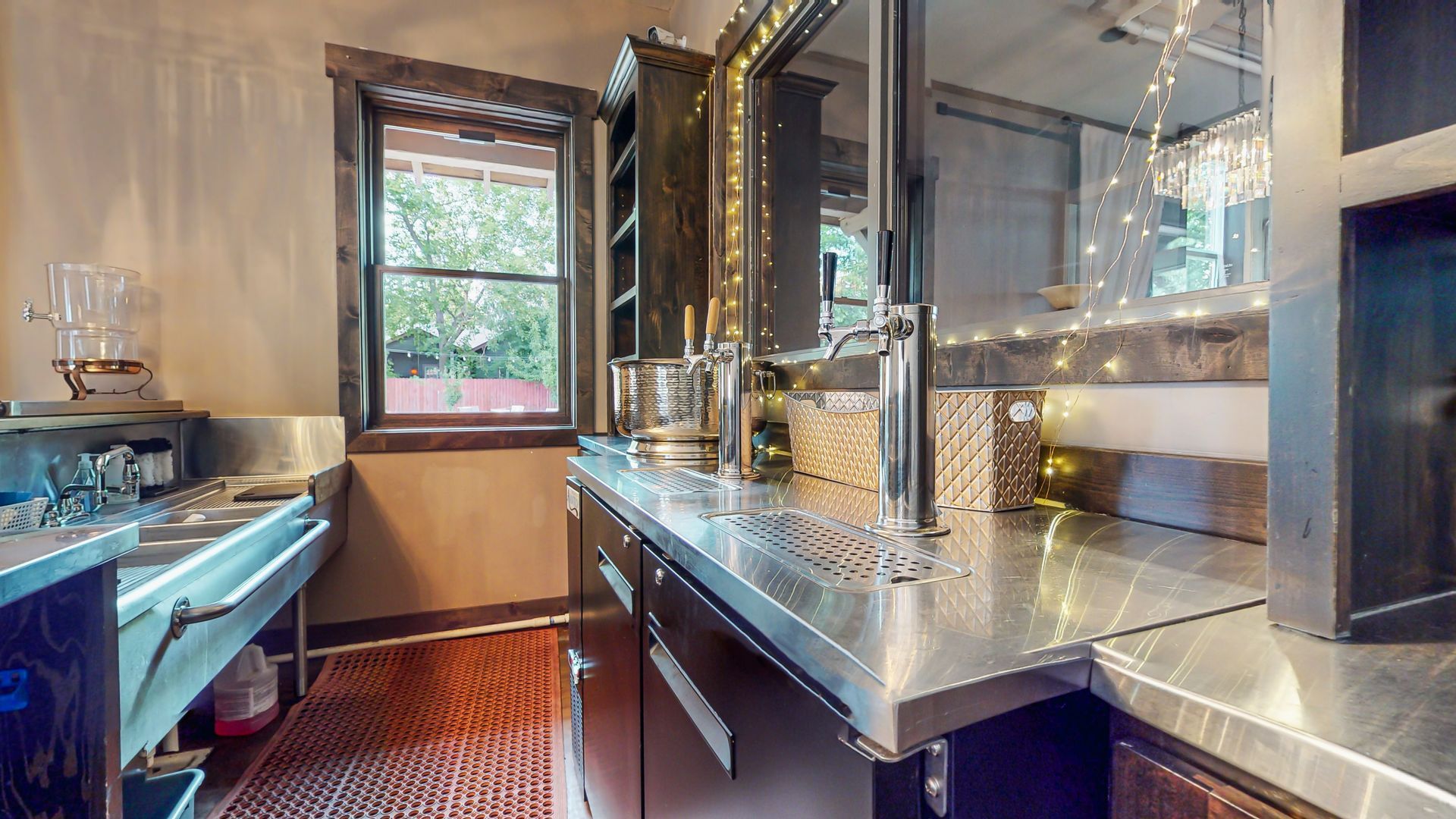A kitchen with a stainless steel counter top and a window.