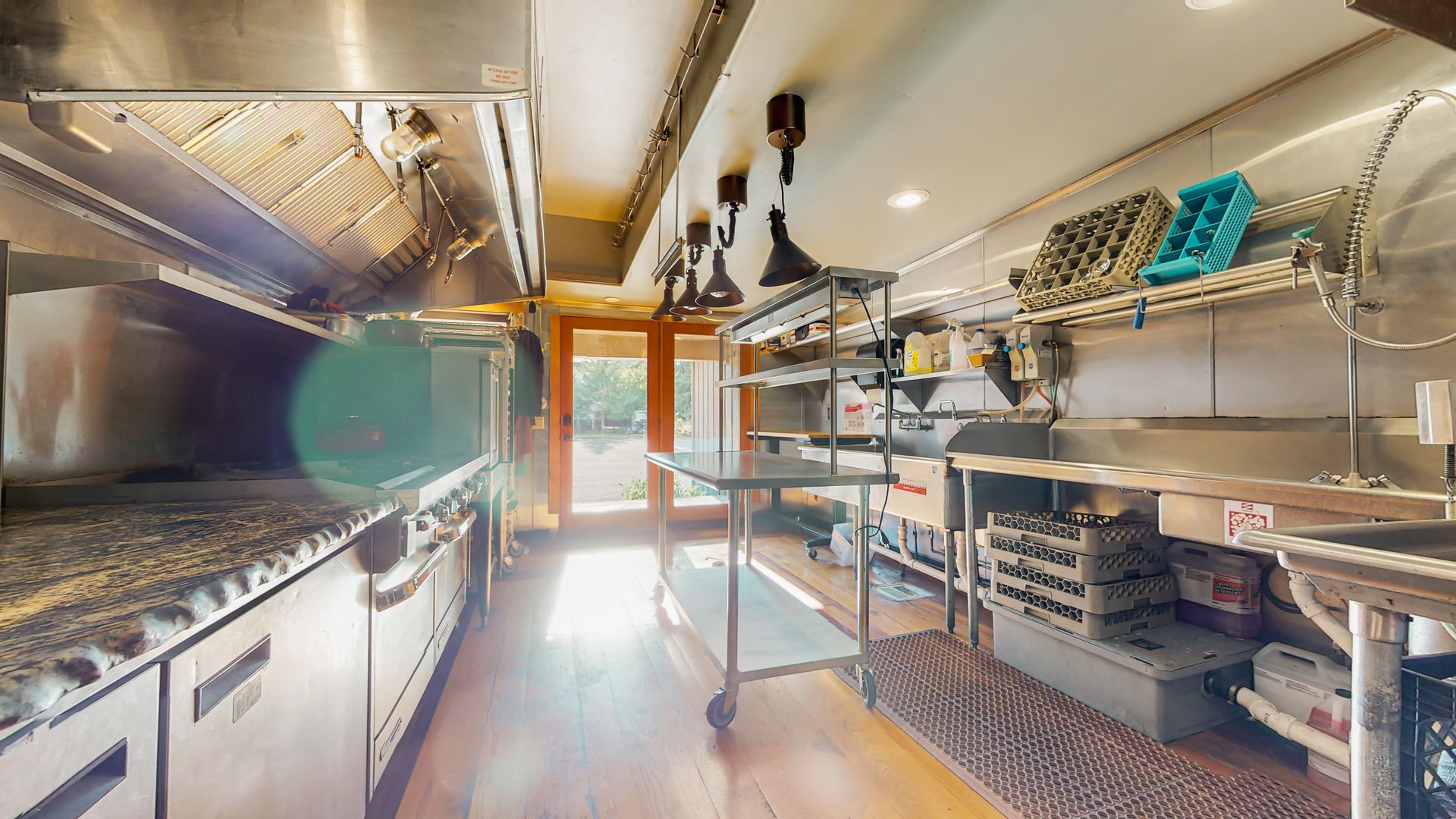 A kitchen with a lot of stainless steel appliances and counter tops.