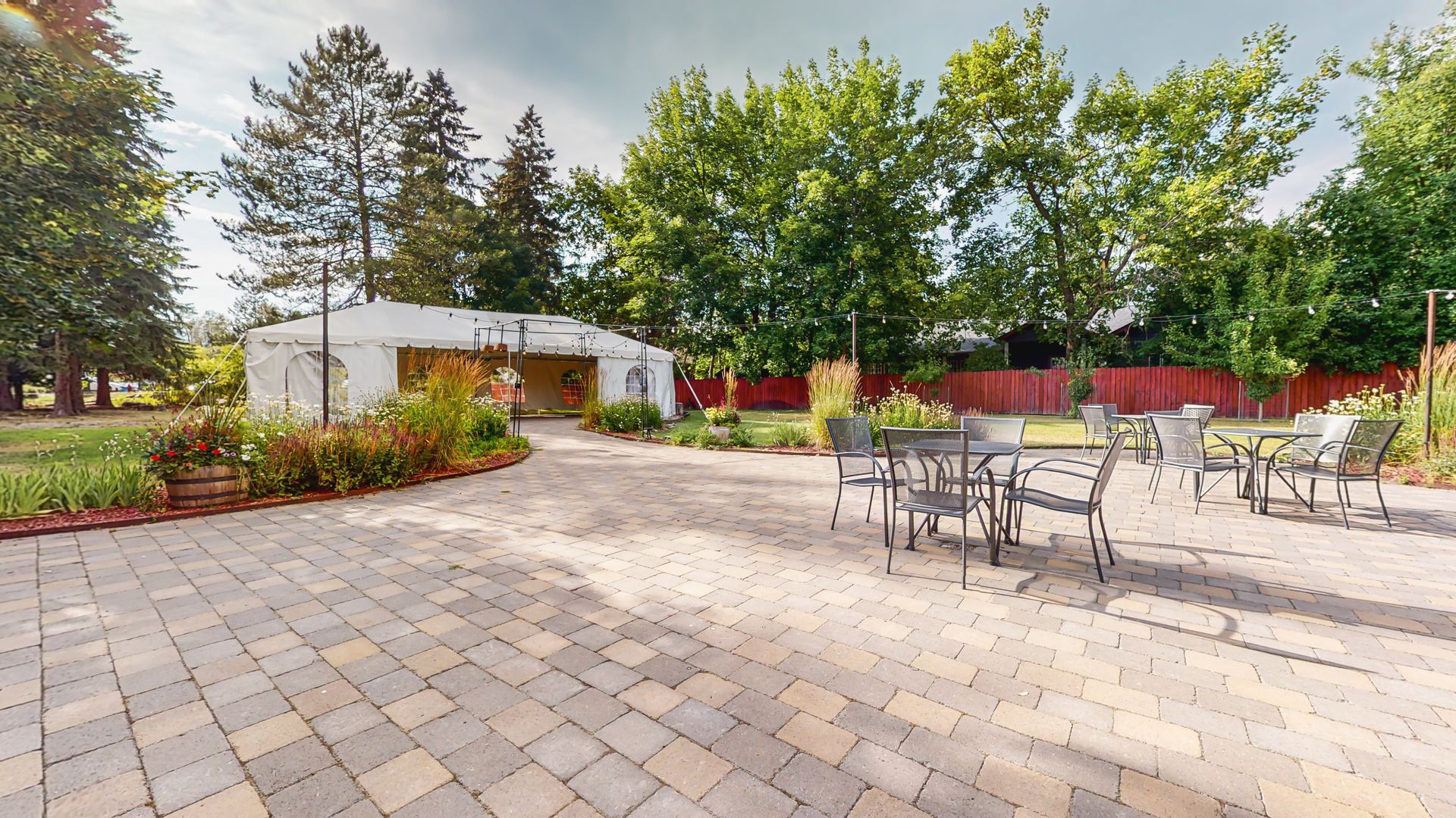 A patio with tables and chairs in front of a house