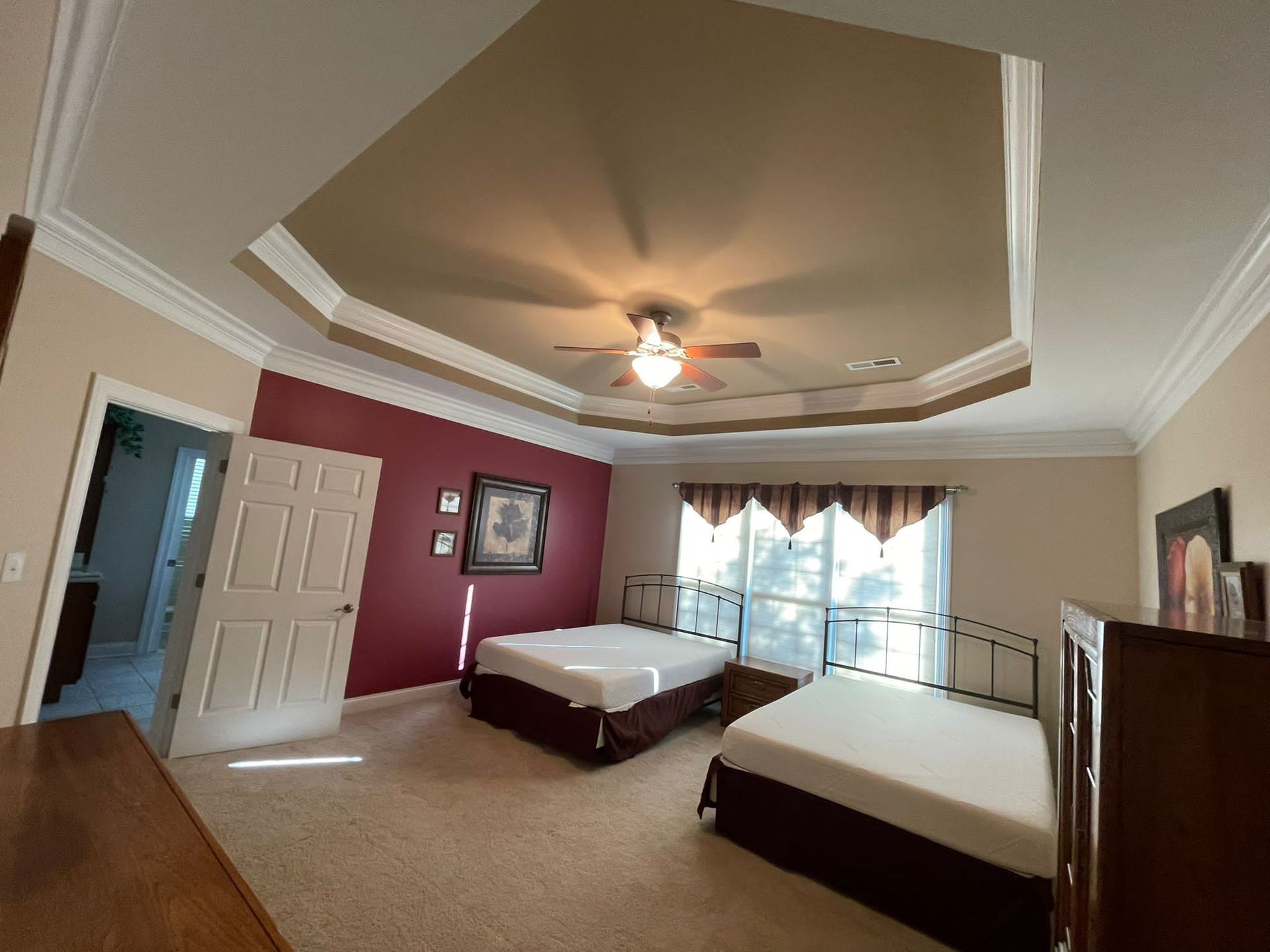A bedroom with two beds and a ceiling fan
