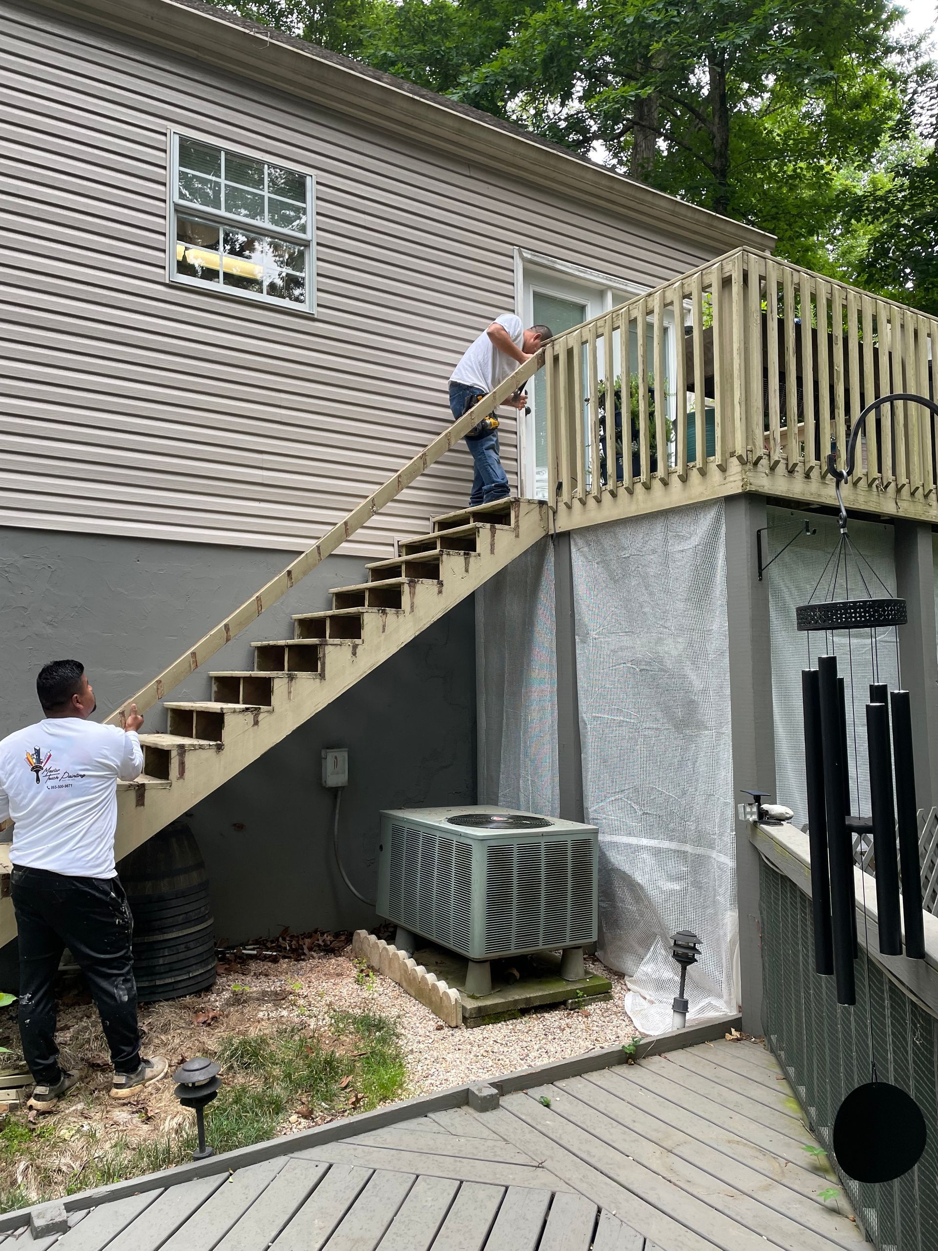 A man is standing on a set of stairs next to a house.