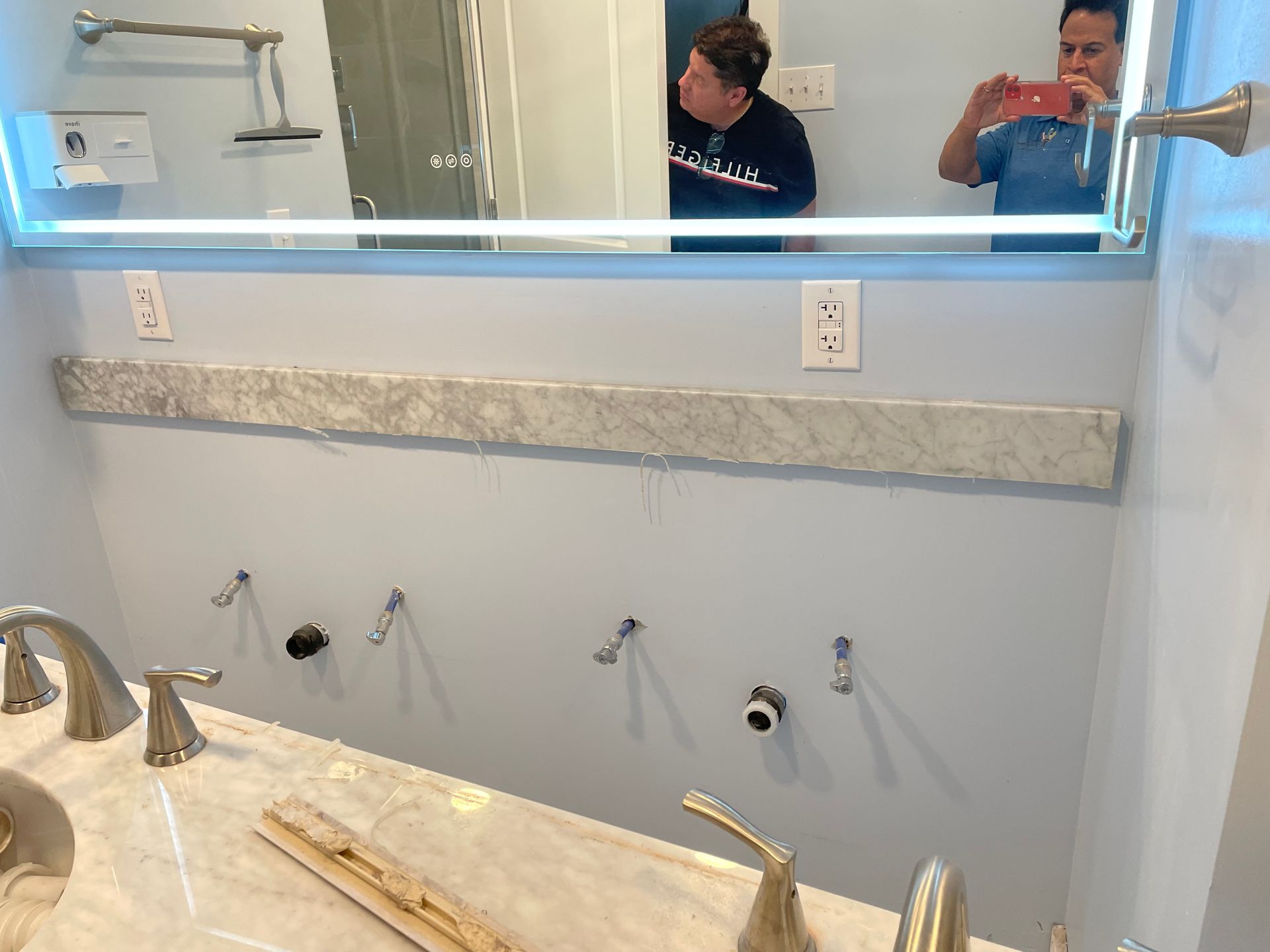 A man is taking a picture of himself in a bathroom mirror.