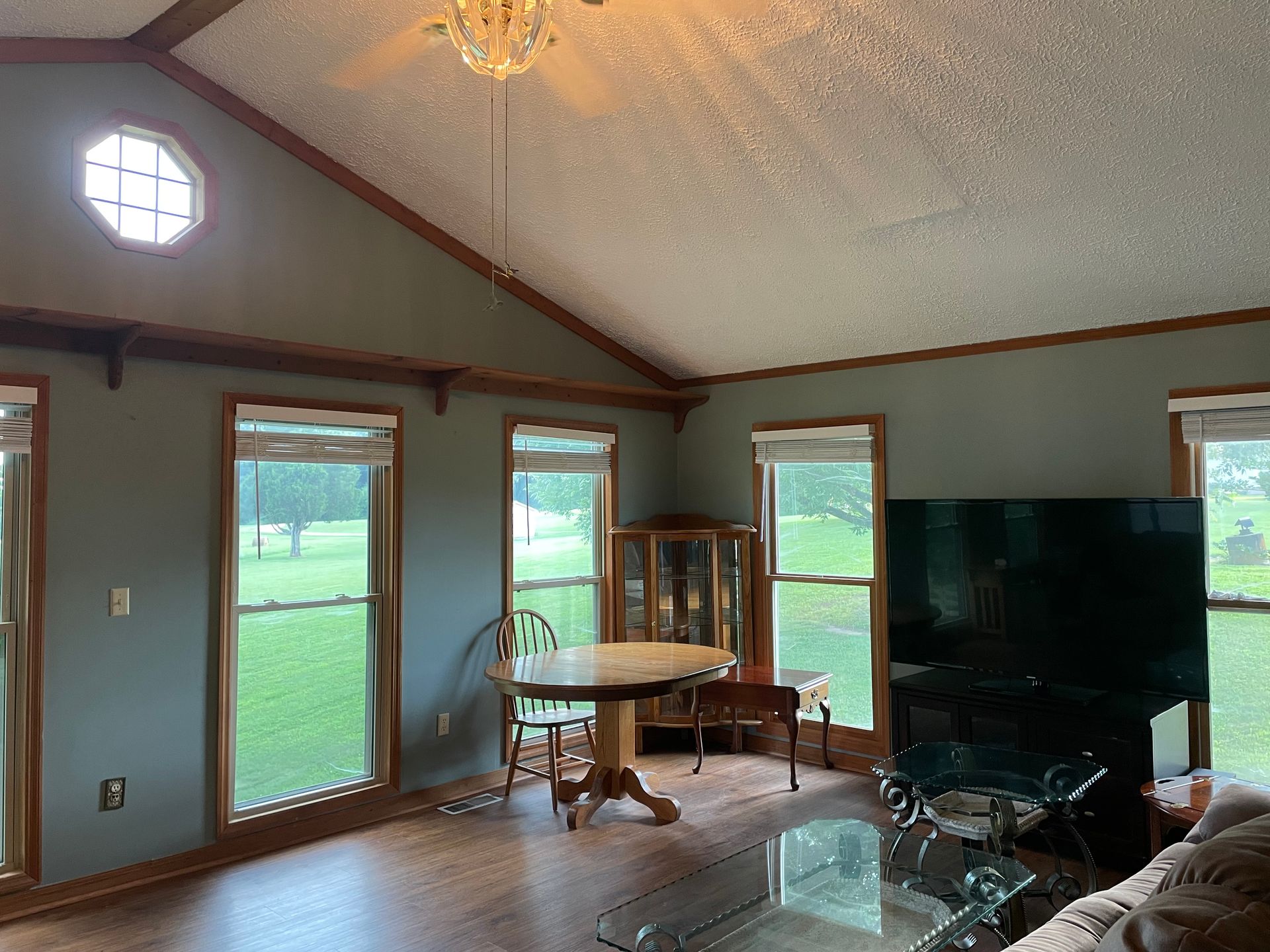 A living room with a table , chairs , and a flat screen tv.