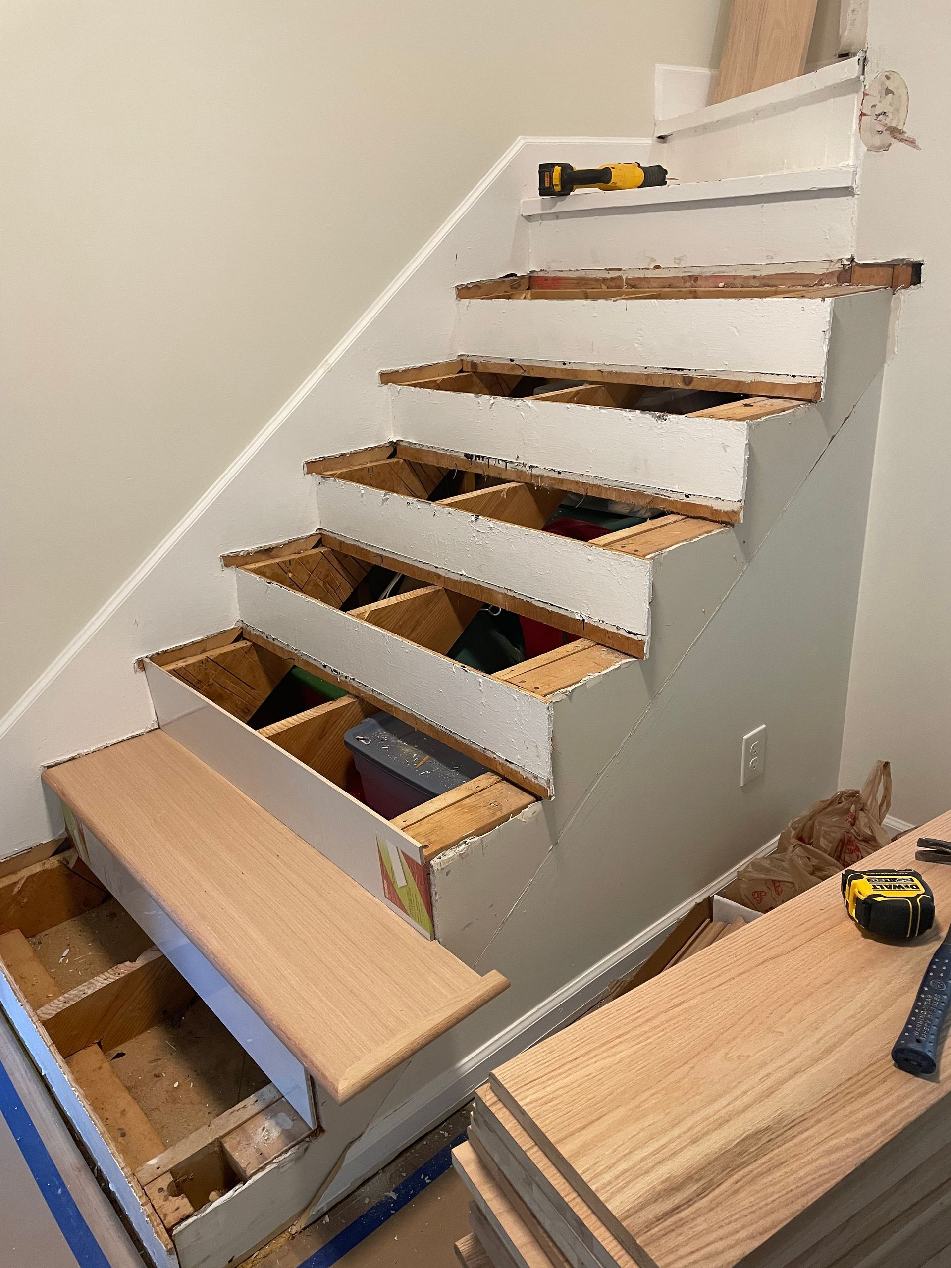 A staircase is being built with wooden steps and a drawer underneath it.