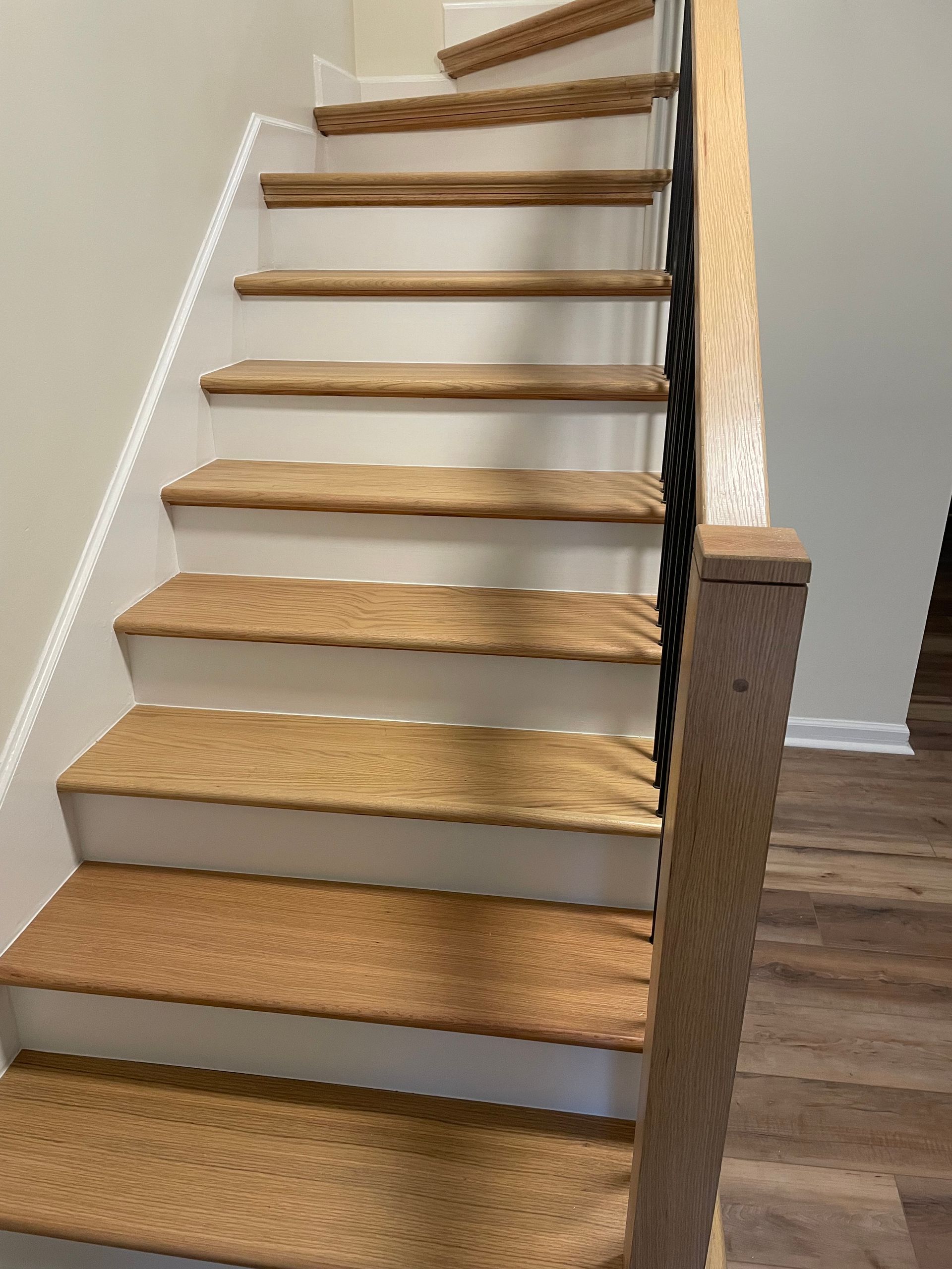 A staircase with wooden steps and a metal railing in a house.