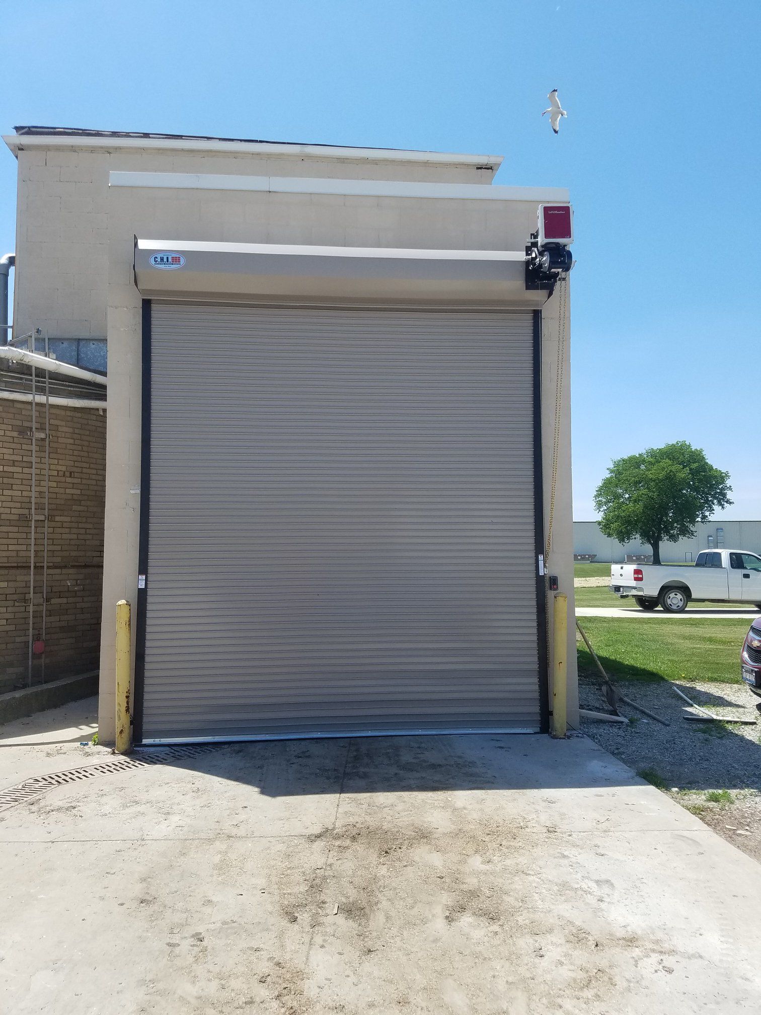 A white truck is parked in front of a garage door