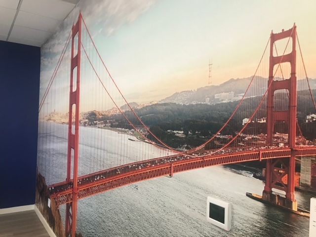 There is a picture of the golden gate bridge on the wall
