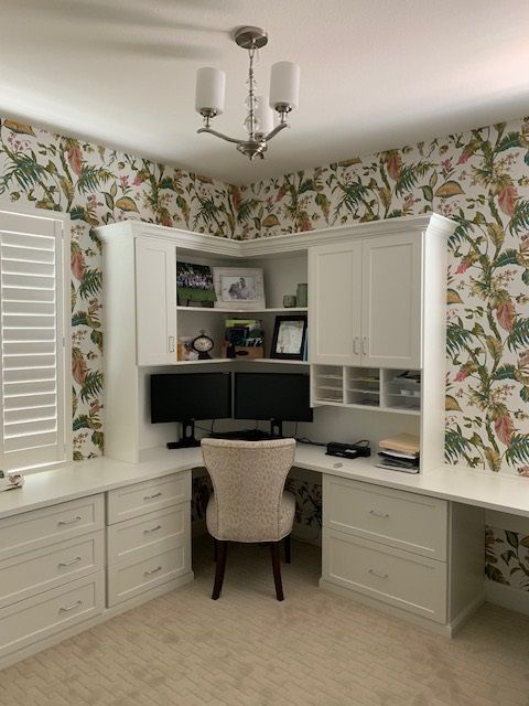 A home office with two computer monitors and a chair
