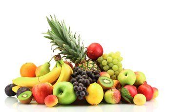 A pyramid of fresh kiwi, pineapple, lemongs, grapes and apples