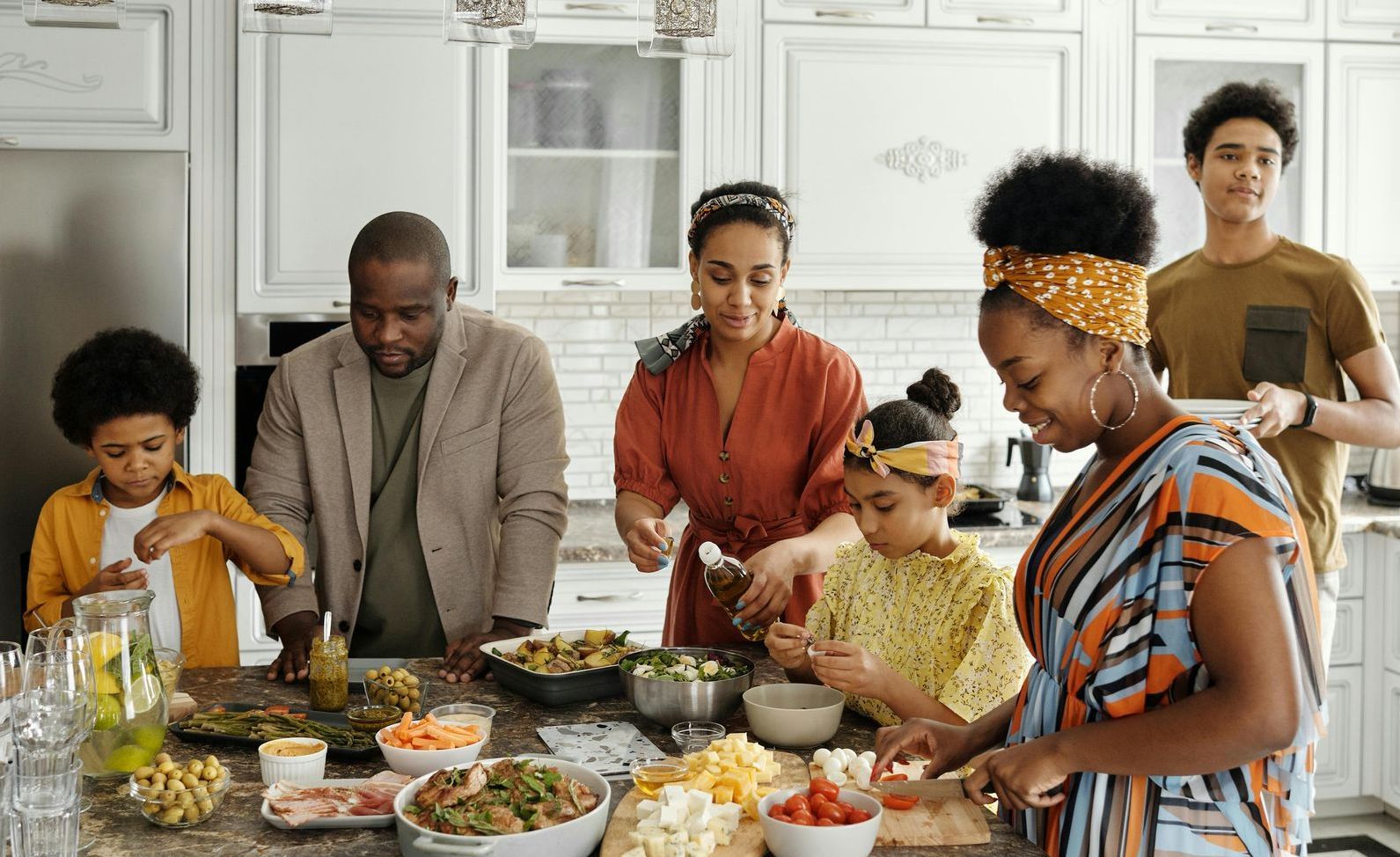 Family preparing food together in a bright kitchen; joy and togetherness.